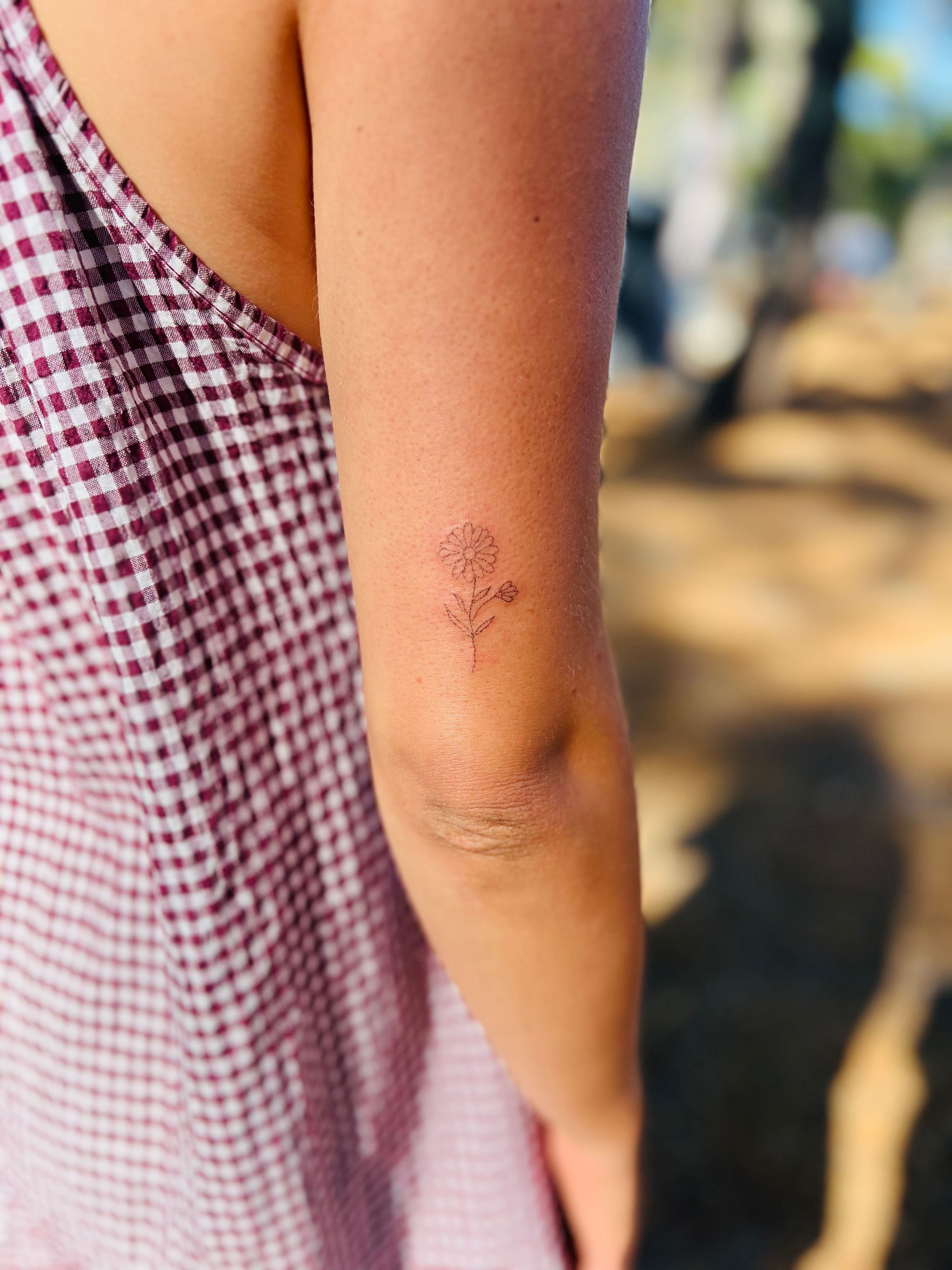 Fineline handpoke flower im Line Work Style auf Oberarm von Tatatat in Augsburg