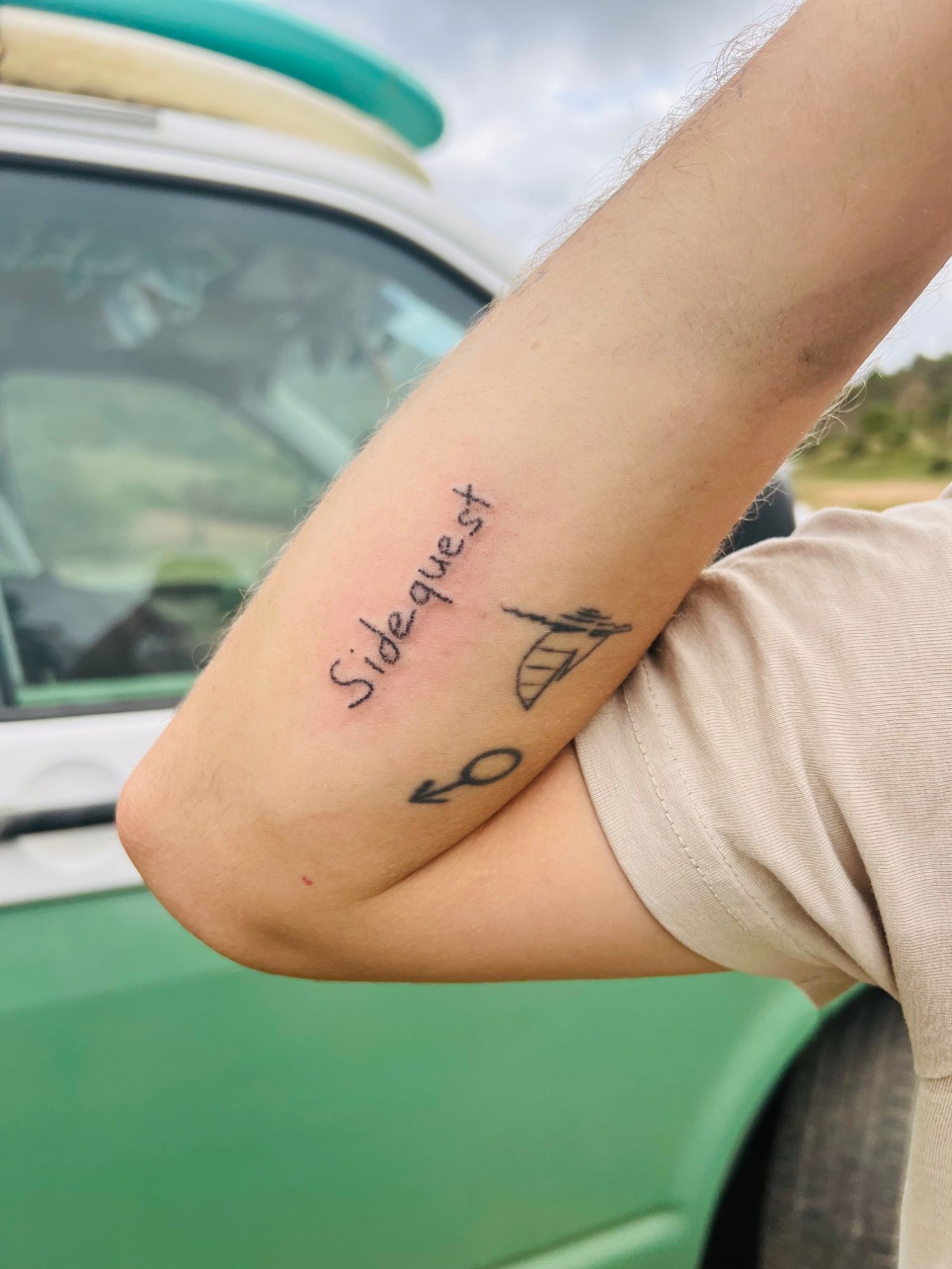 Sidequest | handpoke lettering im Line Work Style auf Oberarm von Tatatat in Augsburg