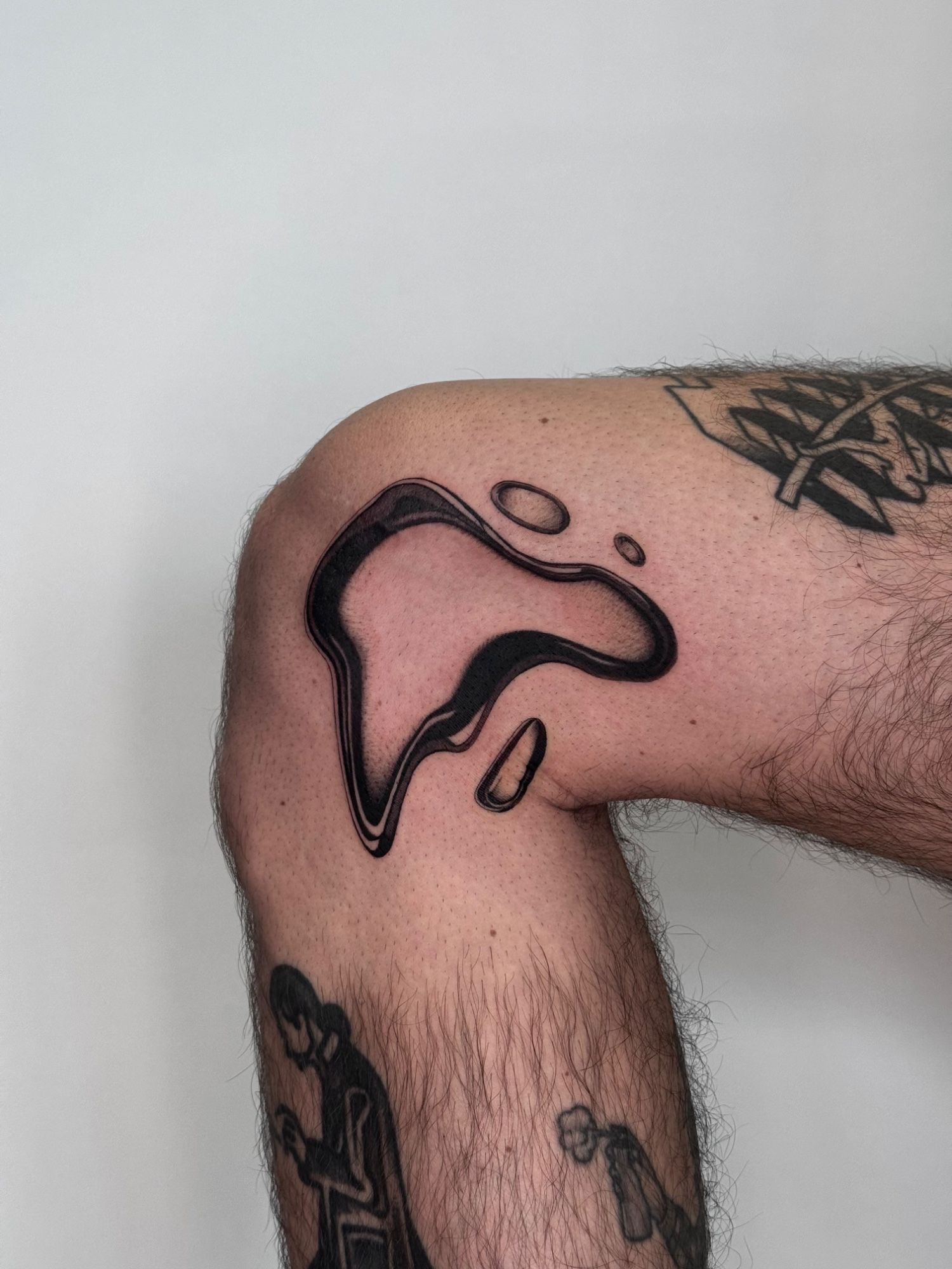 Chrome Drop Wanna Do im Abstract Style auf Bein von launau.tattoo in Leipzig