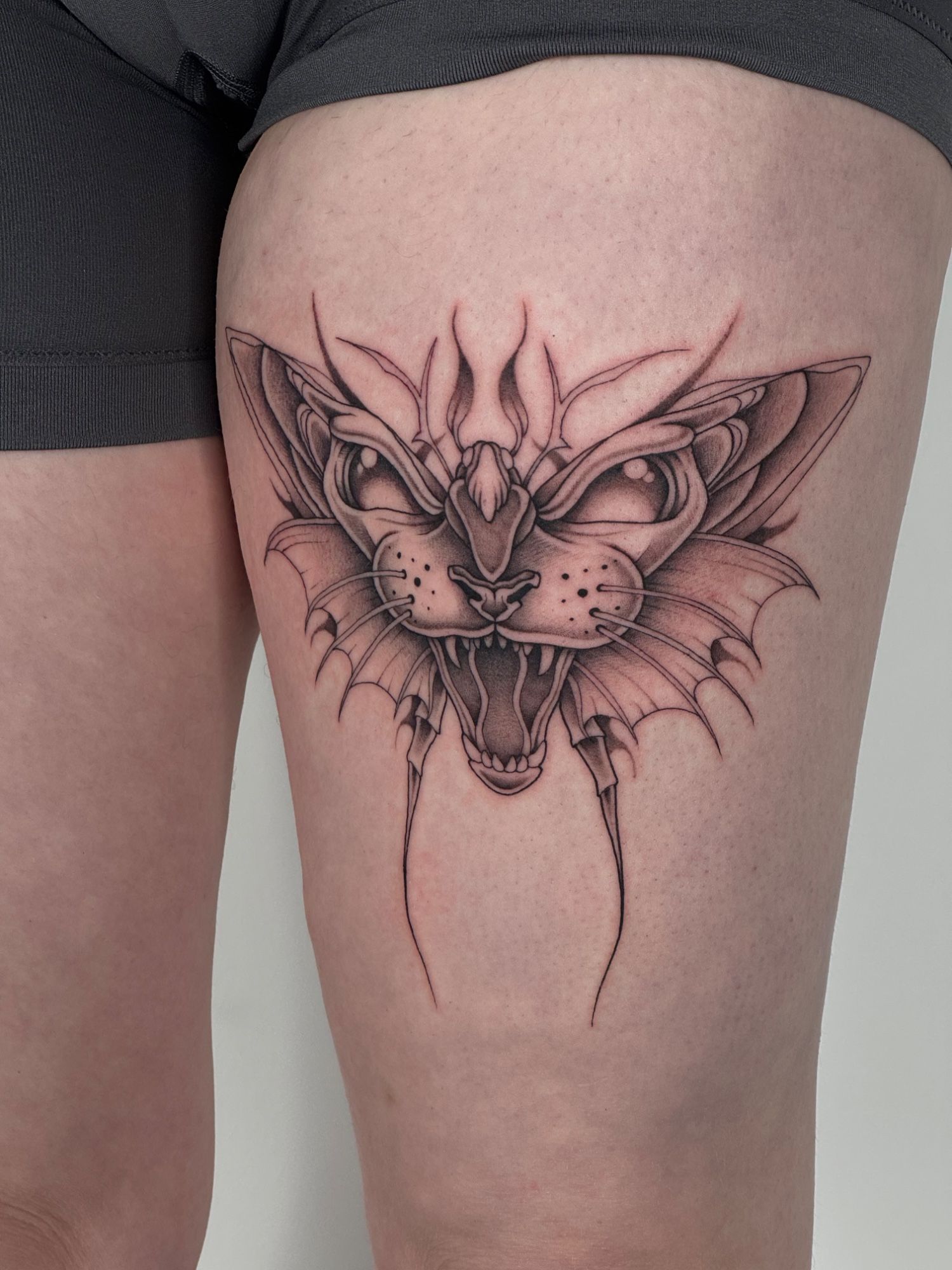 Cat Moth Wanna Do im Black & Gray Style auf Oberschenkel von launau.tattoo in Leipzig