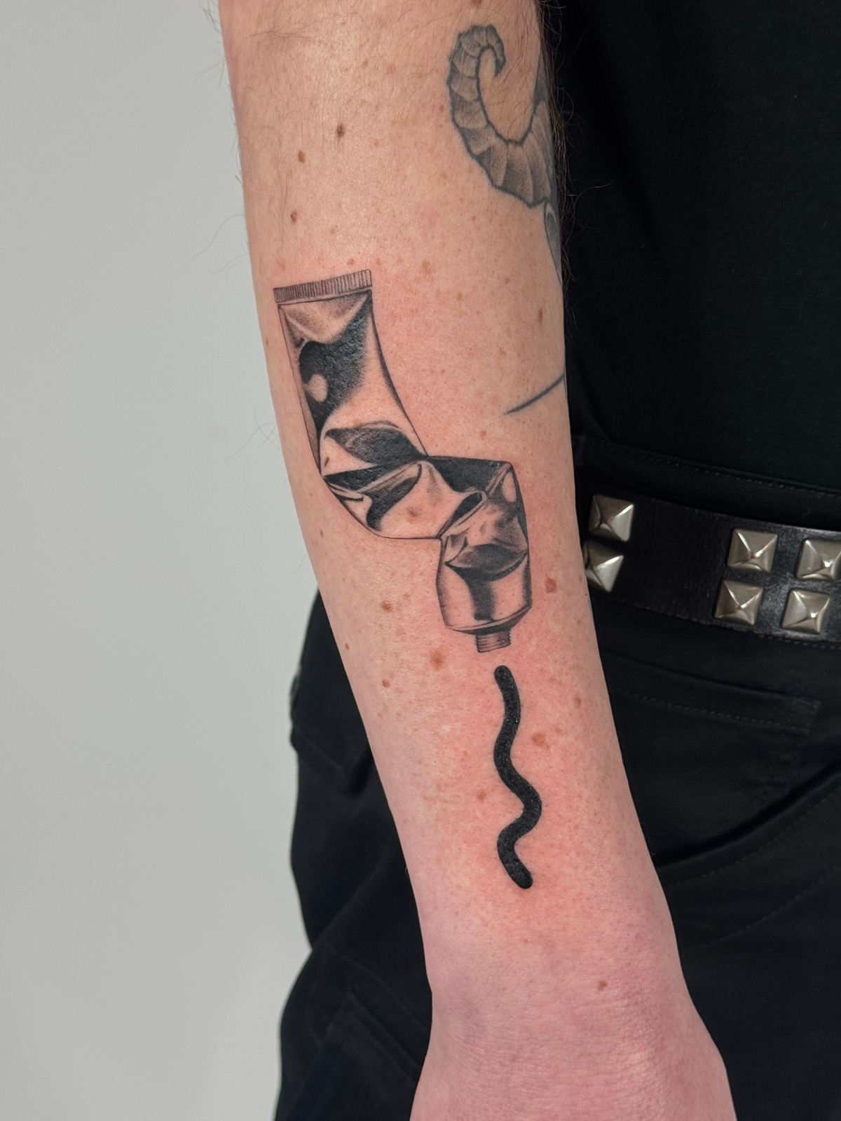 Chrom Tube Wanna Do in Black & Gray style on Forearm by launau.tattoo Leipzig