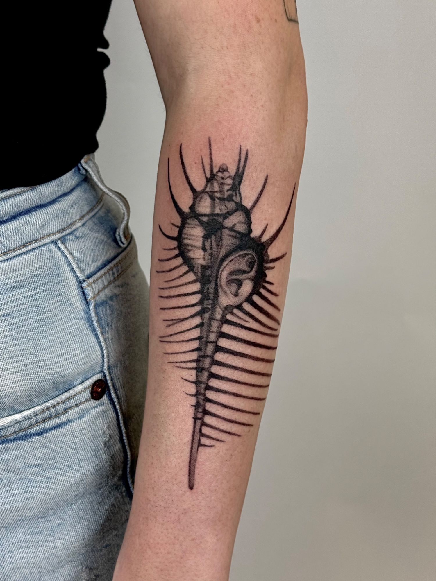 Ohrmuschel Wanna Do im Black & Gray Style auf Unterarm von launau.tattoo in Leipzig