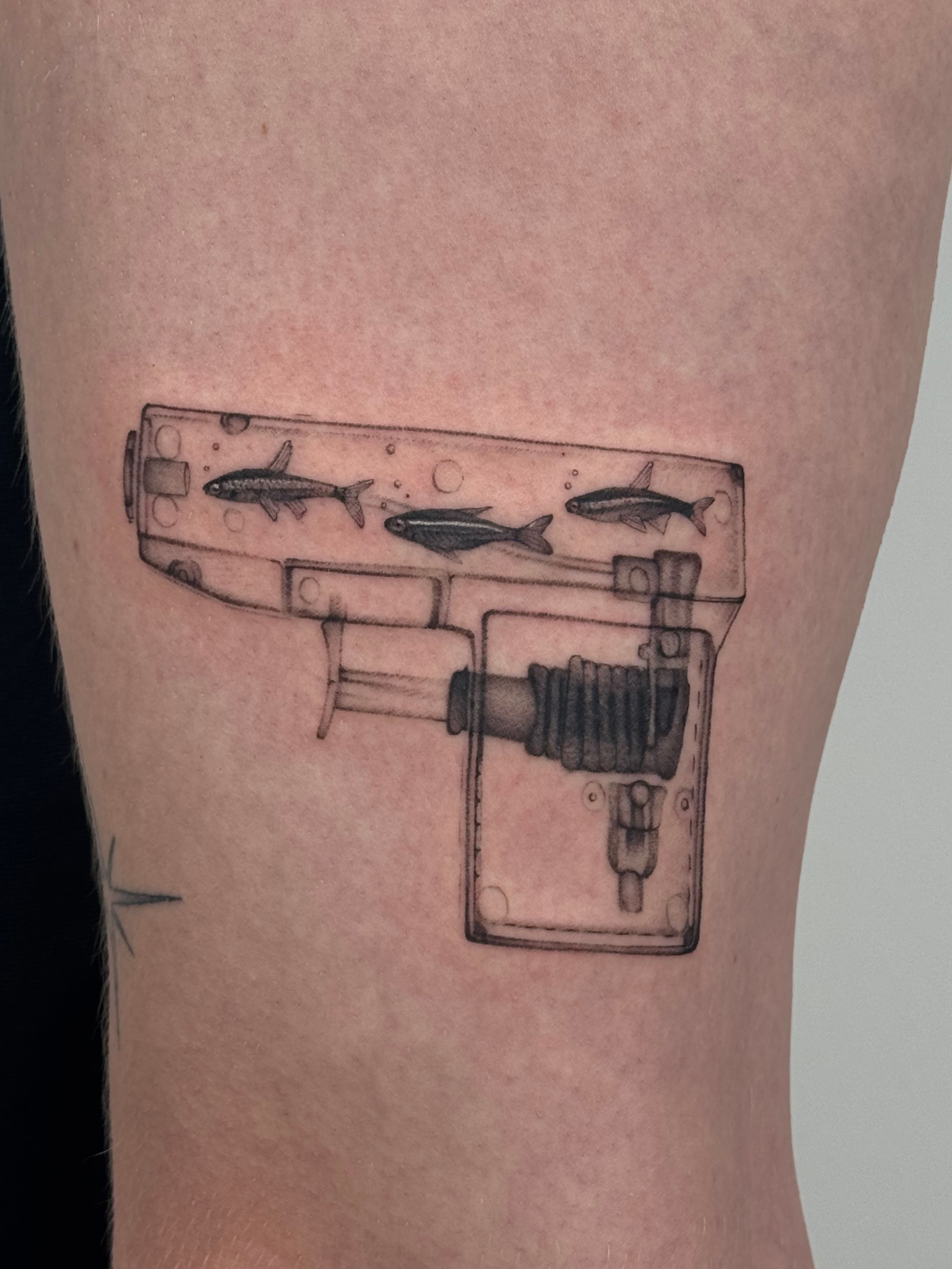 Fischi Pistole Wanna Do im Surrealismus Style auf Oberschenkel von launau.tattoo in Leipzig