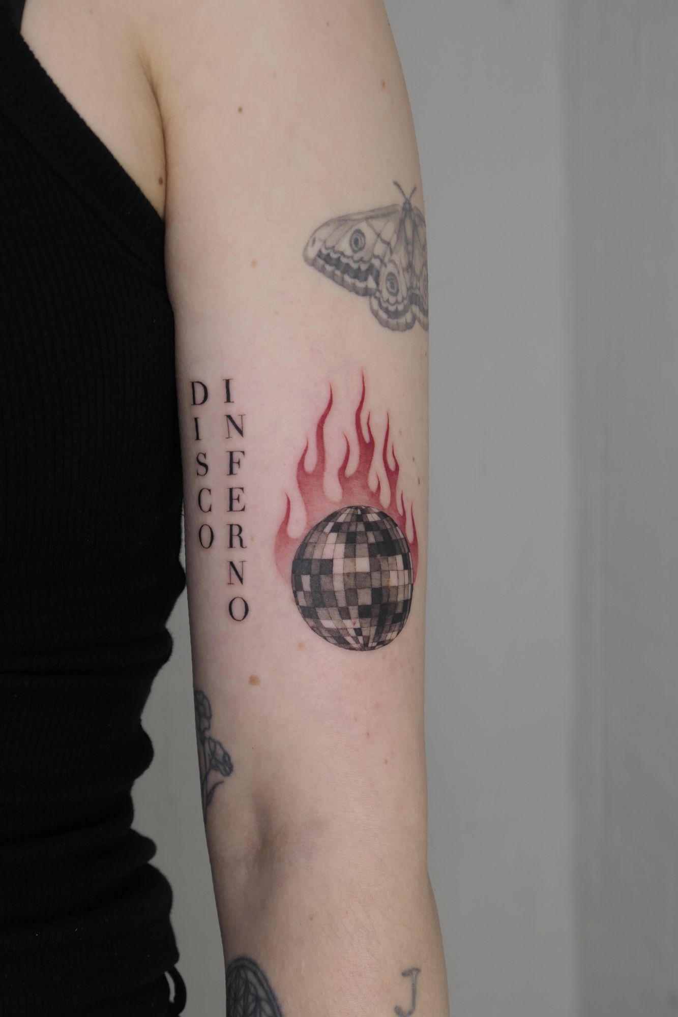 Brennende Discokugel und Schriftzug im Black & Gray Style auf Oberarm von Atelier Flux in Leipzig