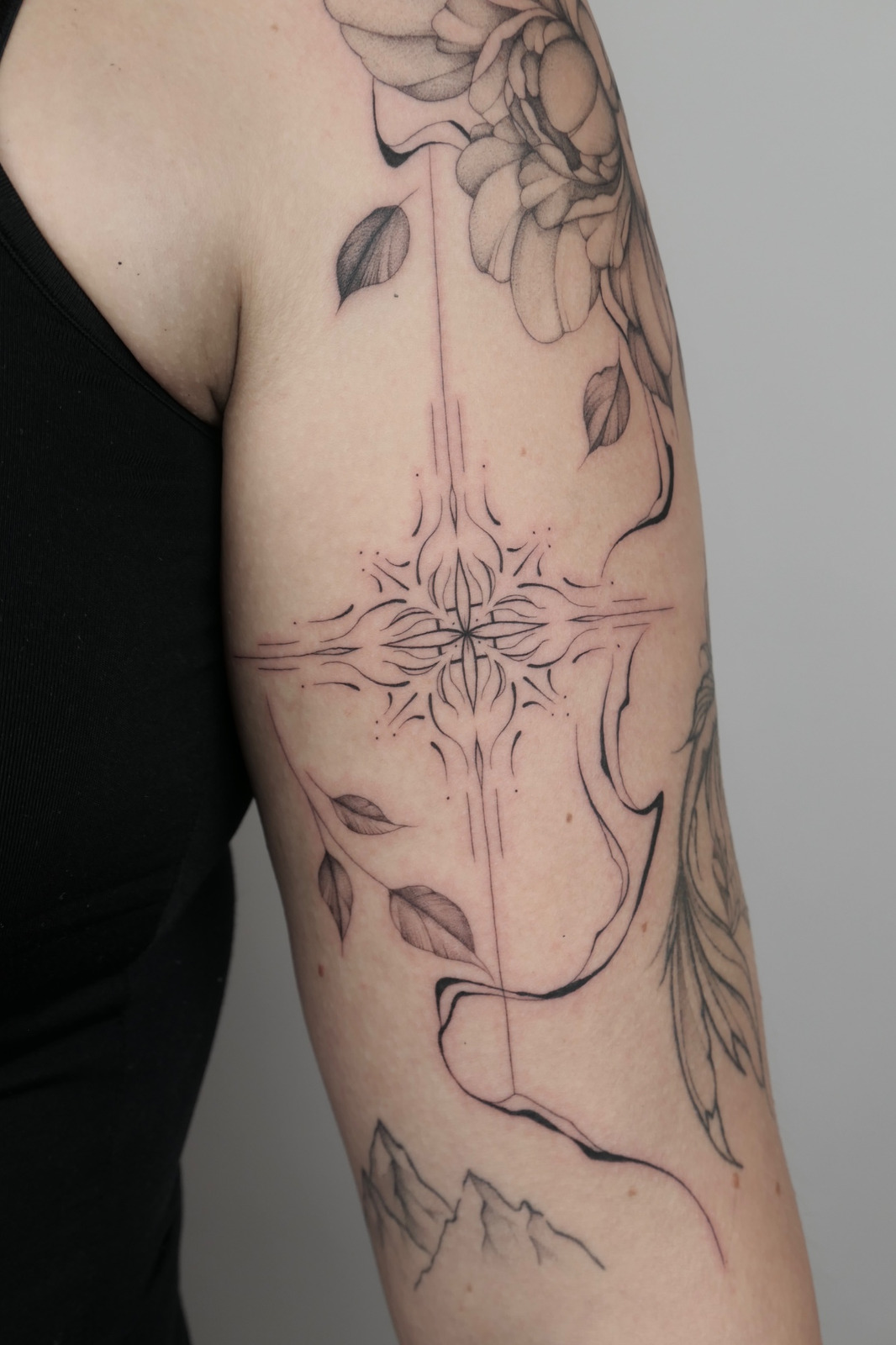 Ornament mit Blumen im Black & Gray Style auf Oberarm von valure.tattoo in Leipzig