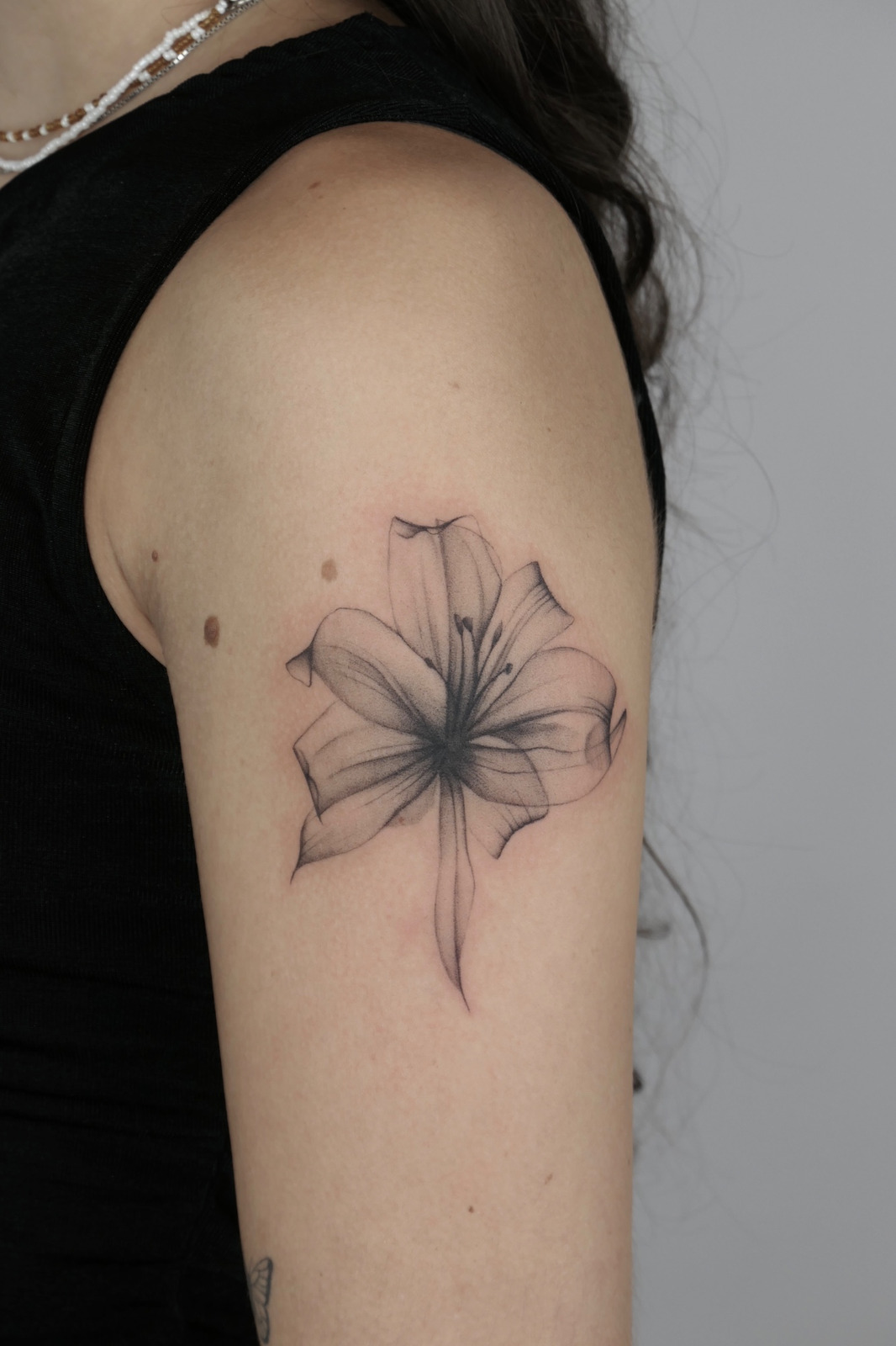 Transparente Blume im Black & Gray Style auf Oberarm von valure.tattoo in Leipzig