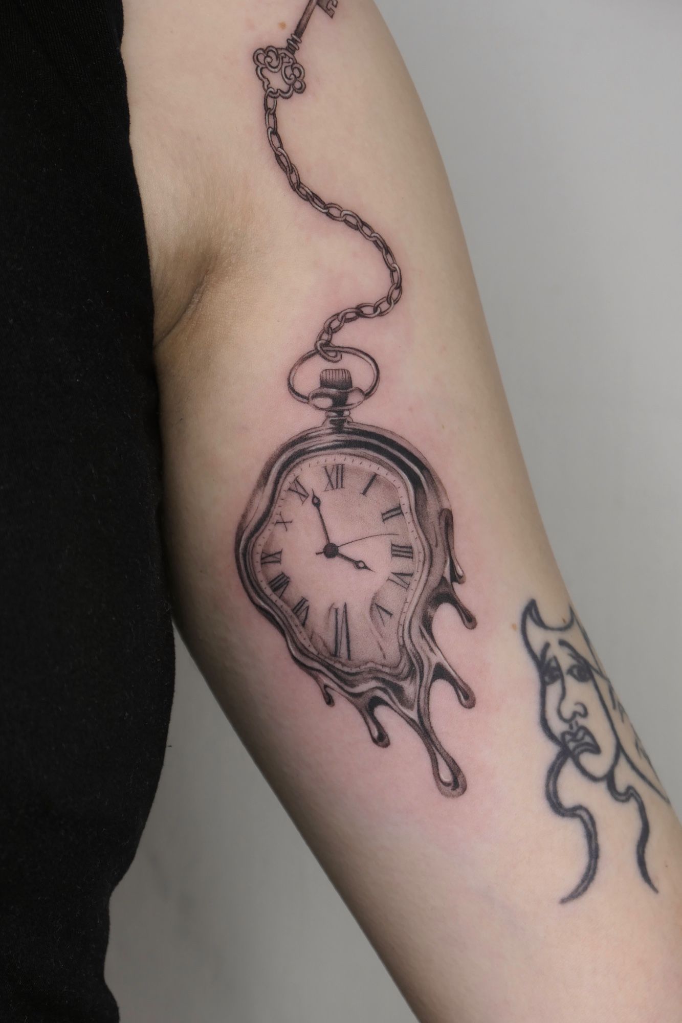Zerlaufende Uhr im Black & Gray Style auf Oberarm von Atelier Flux in Leipzig