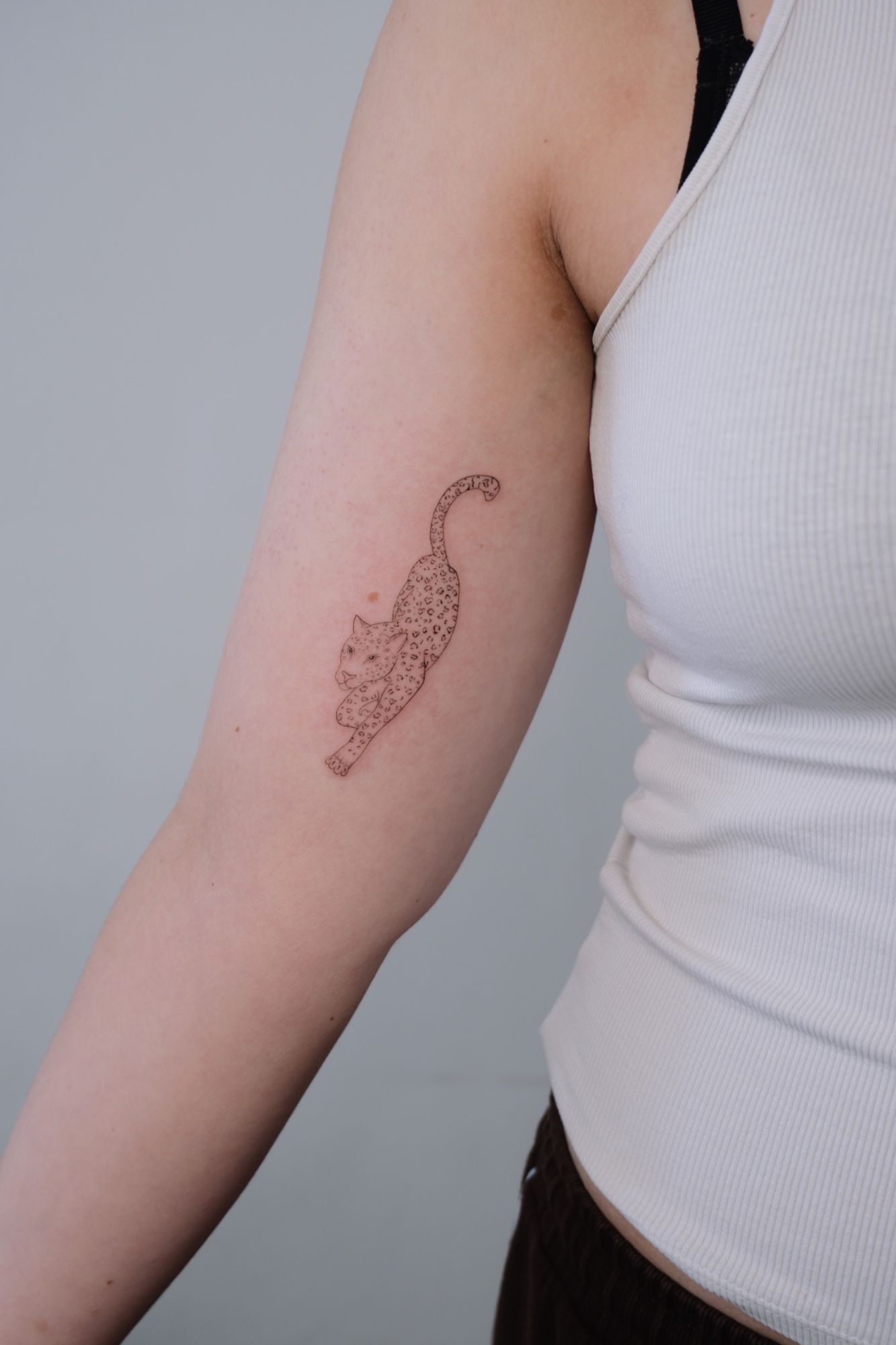 Leopard mit Herzchen im Abstract Style auf Oberarm von @alinaatattoo in 20457