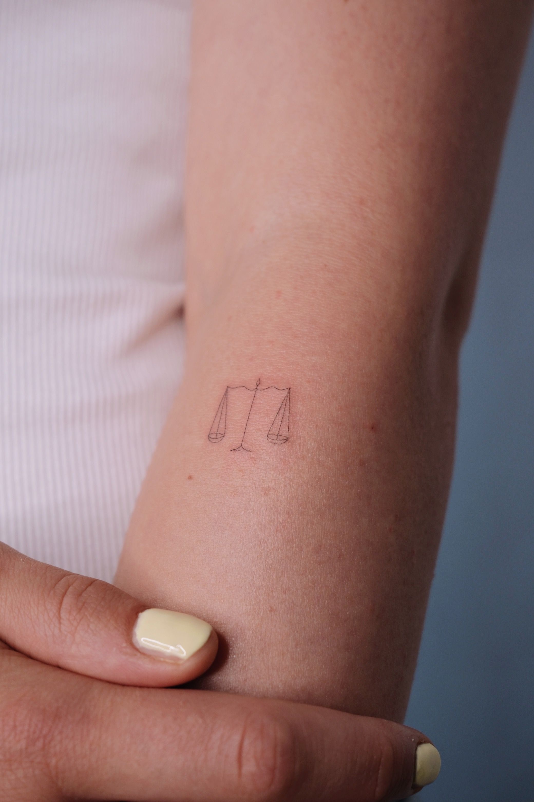 Waage im Fineline Style auf Unterarm von @alinaatattoo in 20457