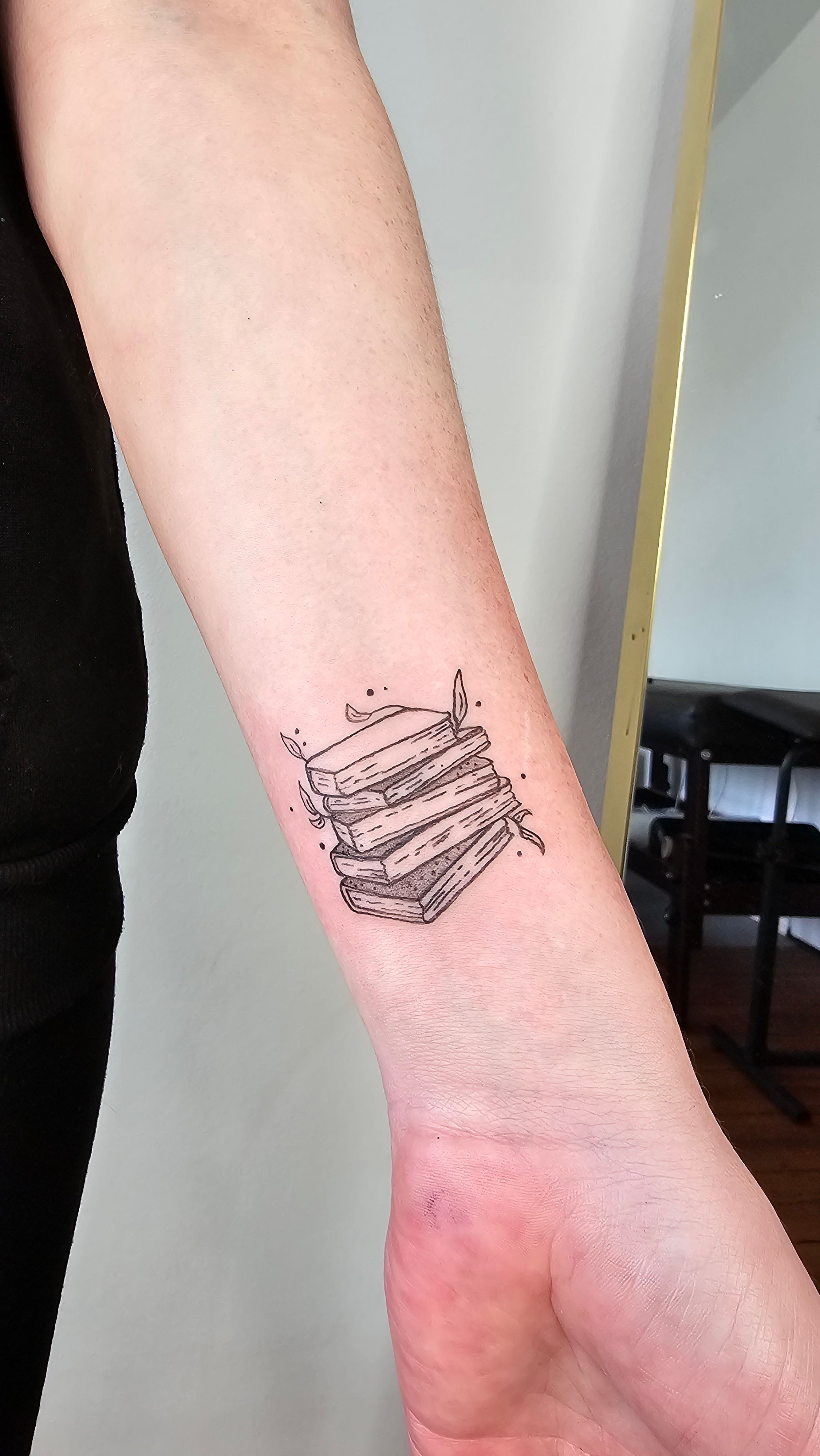 Bücherstapel im Fineline Style auf Unterarm von Nat.inks in Hamburg