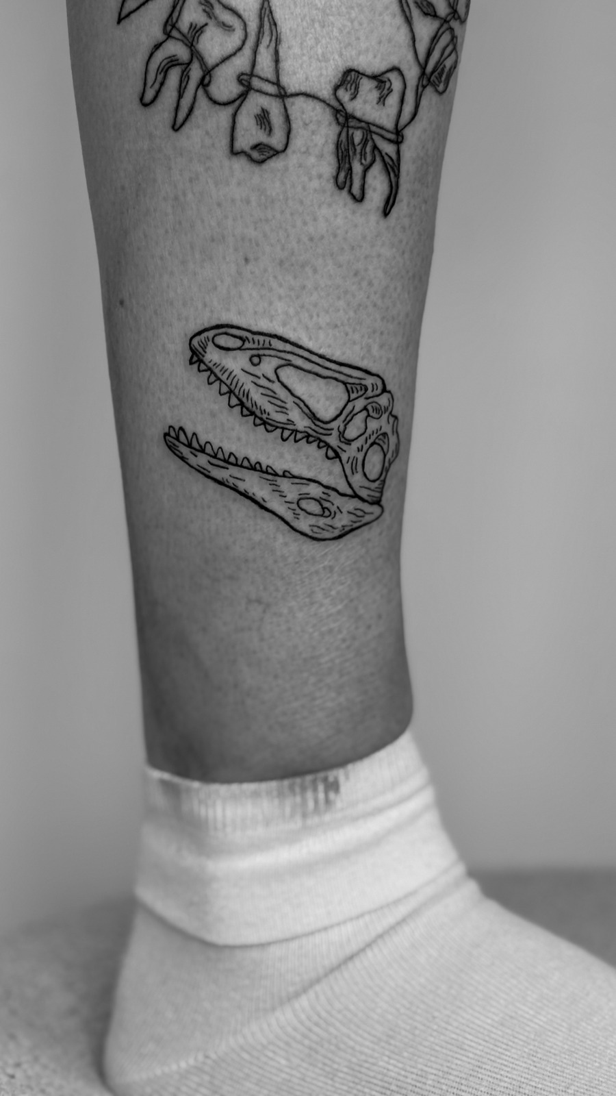 Dino Skull im Ignorant Style auf Bein von Heartbreaker Tattoo in Hamburg
