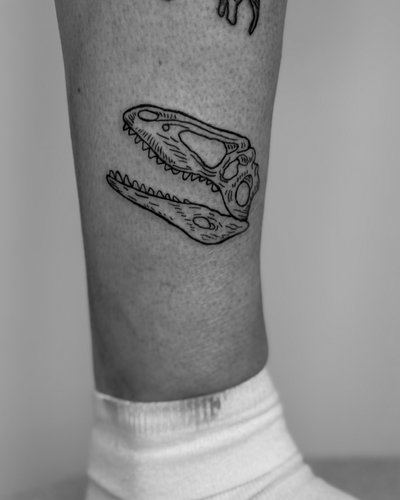 Dino Skull im Ignorant Style auf Bein von Heartbreaker Tattoo in Hamburg