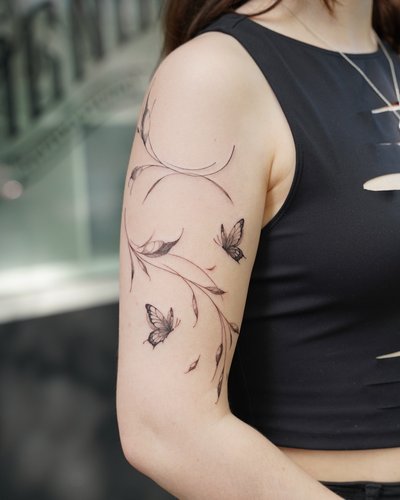 BLUMEN TATTOO im Fineline Style auf Oberarm von Vallfy in Hamburg