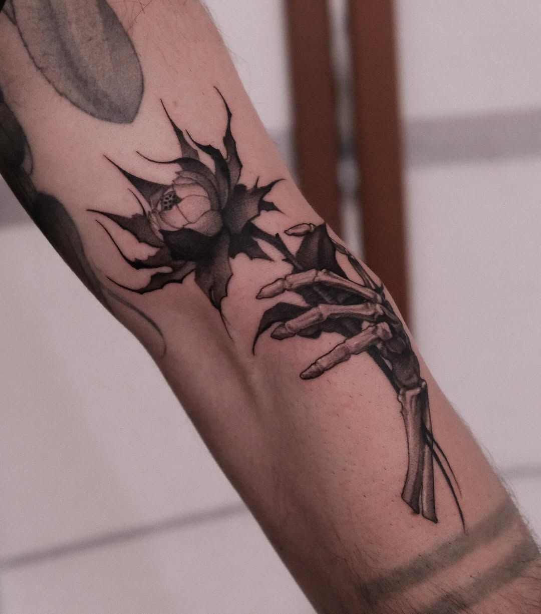 Skeletthand Blume Illustrative Oberarm-Tattoo im Style auf Oberarm von lucy tattoo hamburg in