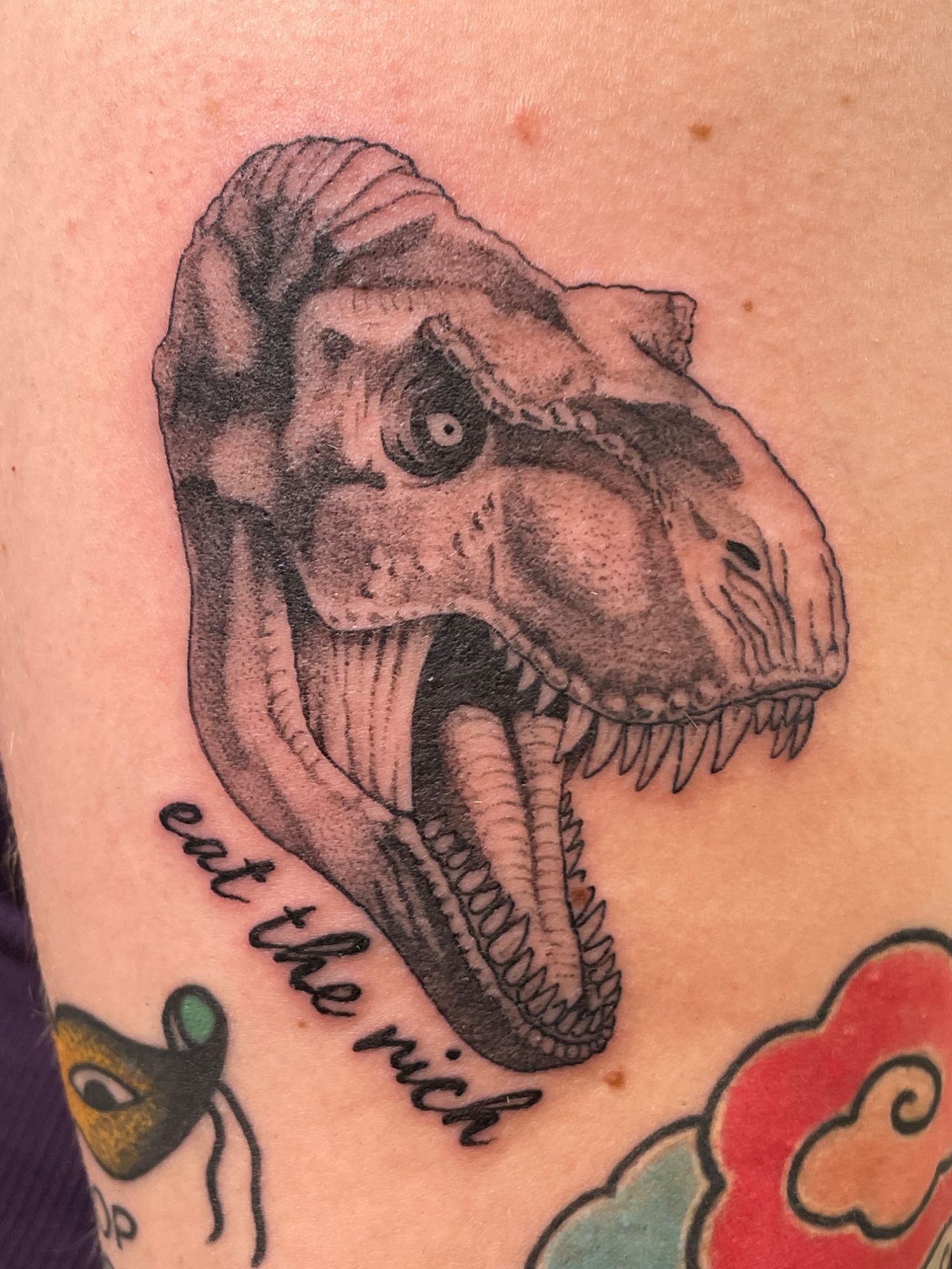 eat-the-rich T-Rex Oberarm im Blackwork Style auf von Pretty Bold in Hamburg