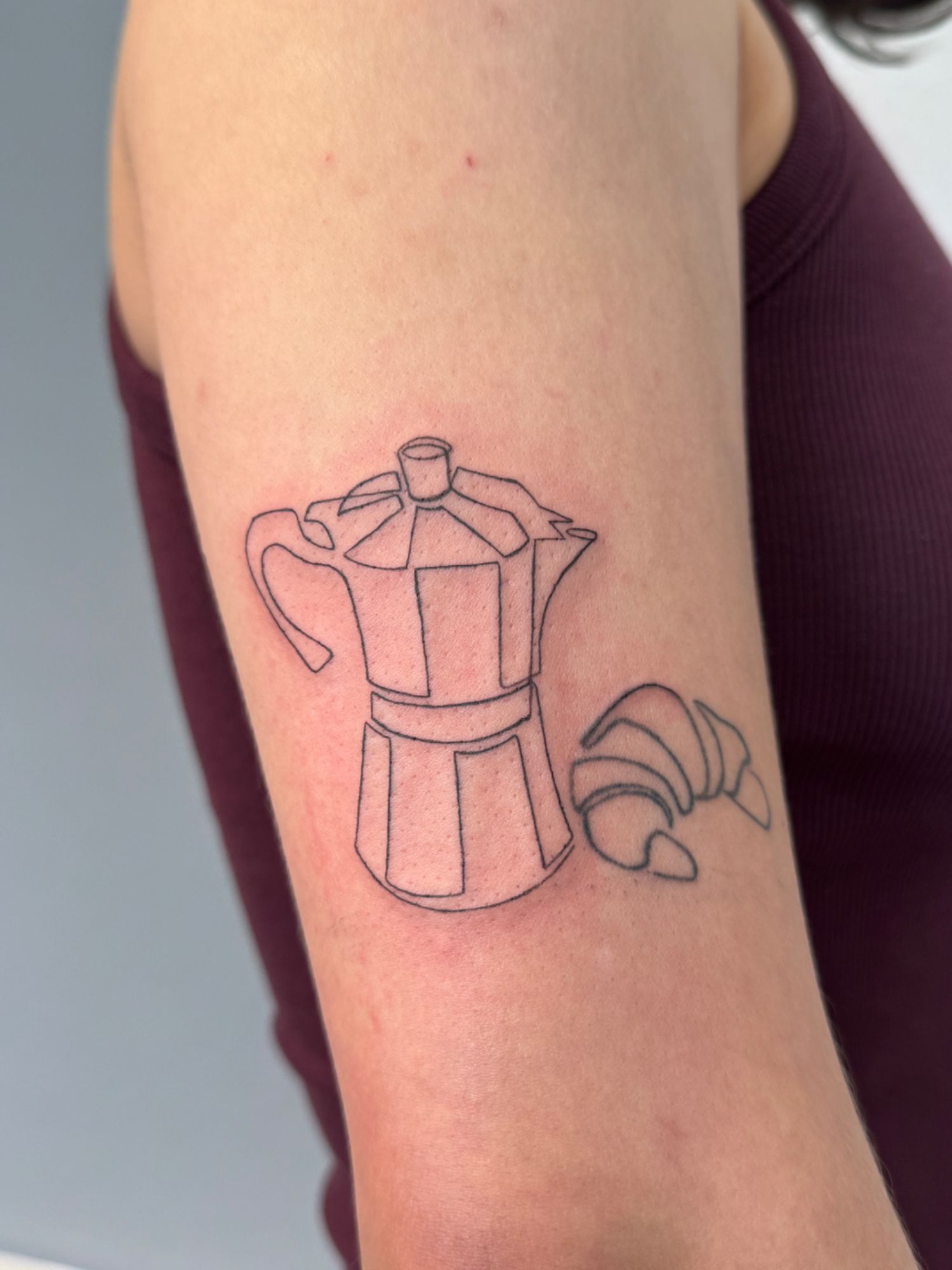 Fineline Croissant und French Press im Style auf Oberarm von faeser_inkz in Bramsche