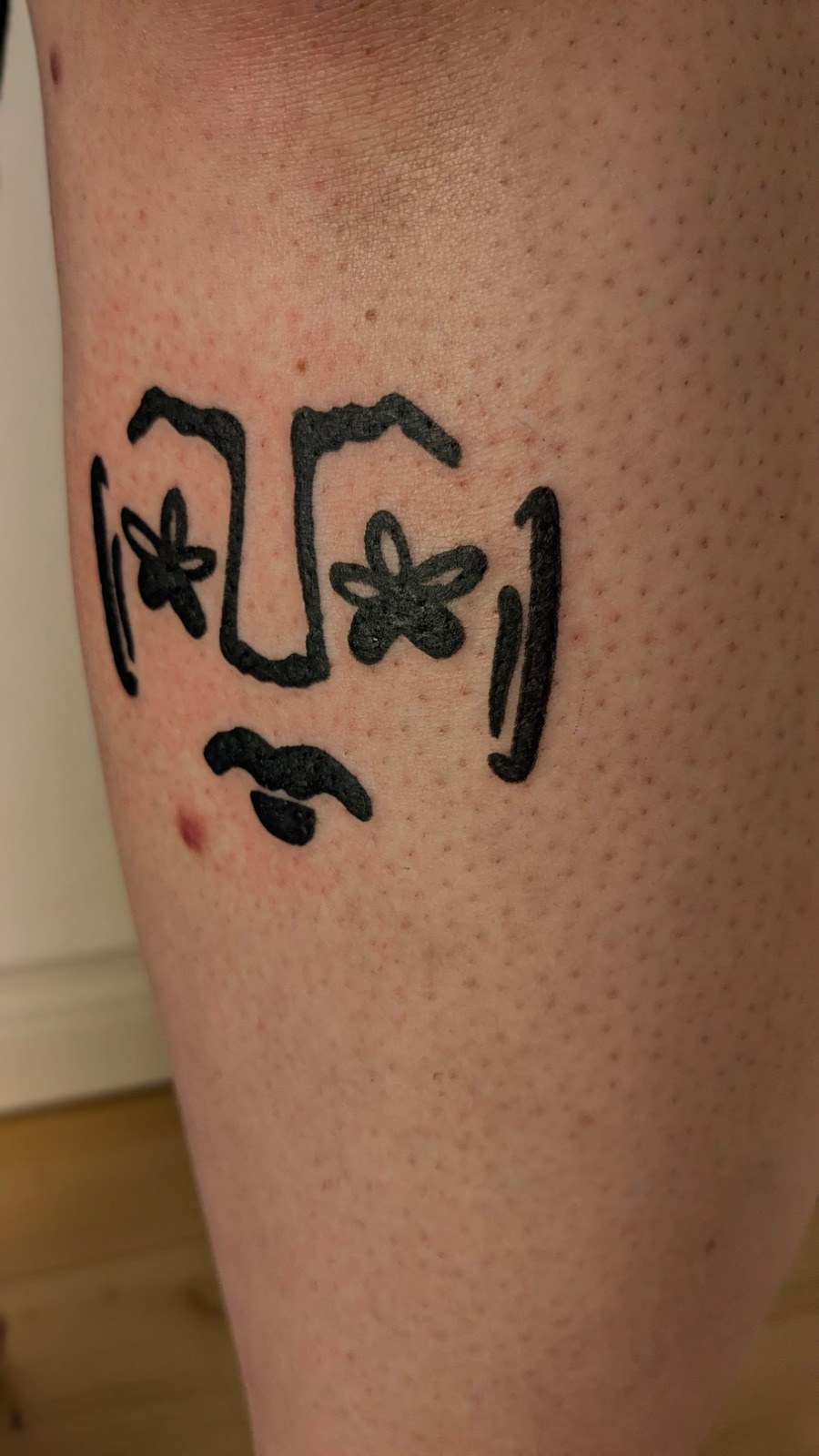 Blumen Gesicht im Blackwork Style auf Bein von janus tattoo in Hamburg