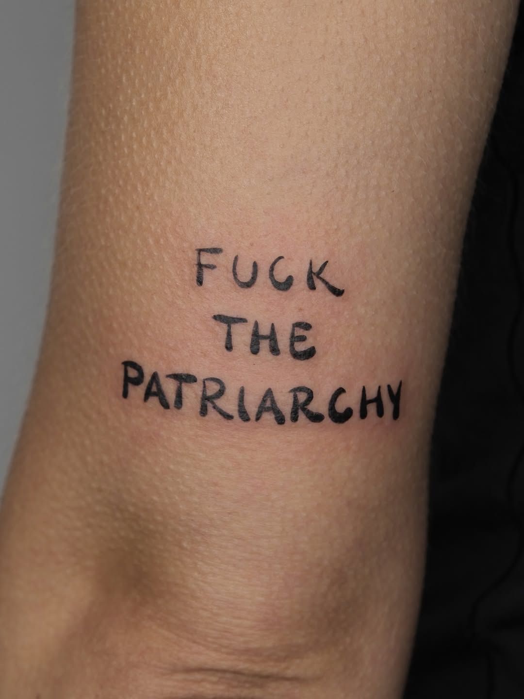 Schriftzug Ignorant Oberarm-Tattoo im Style auf Oberarm von studio_atelier13 in Hamburg