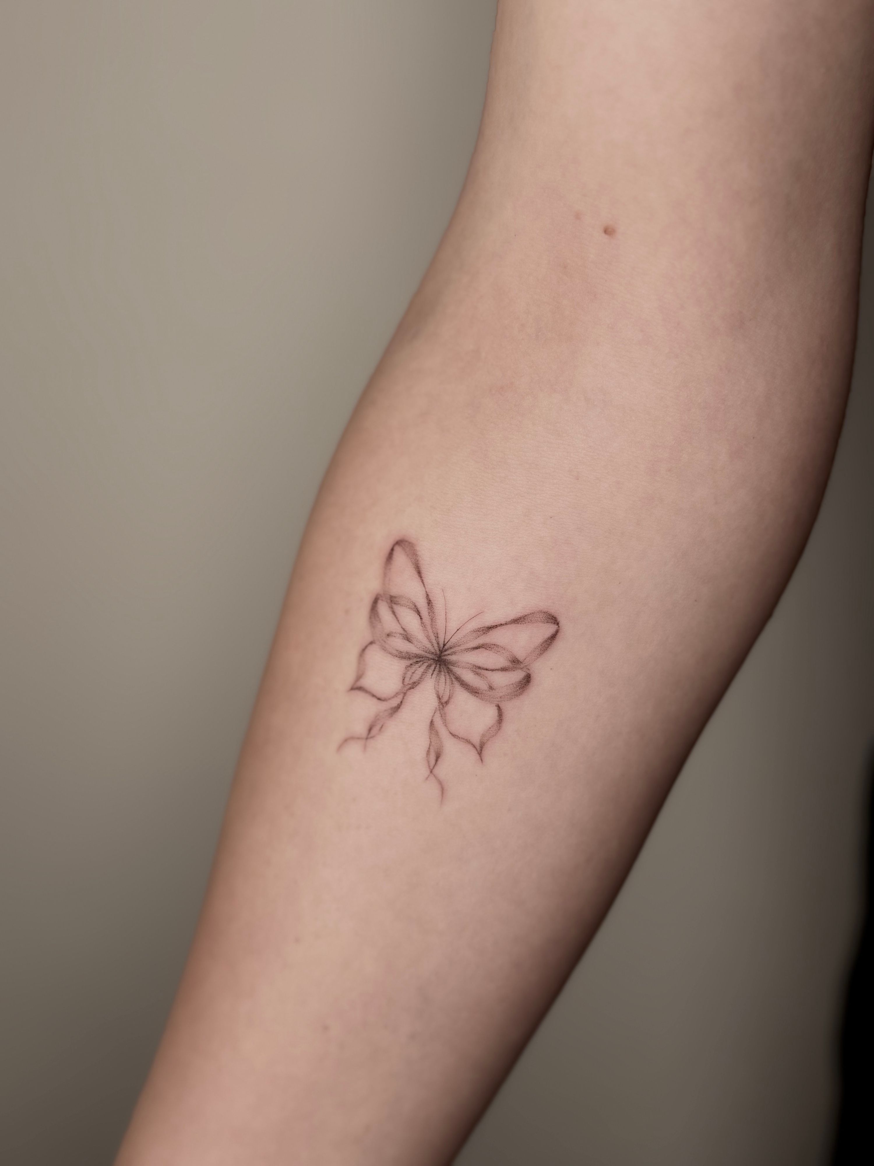 Butterfly bow im Fineline Style auf Unterarm von Ivy Art in Lübeck