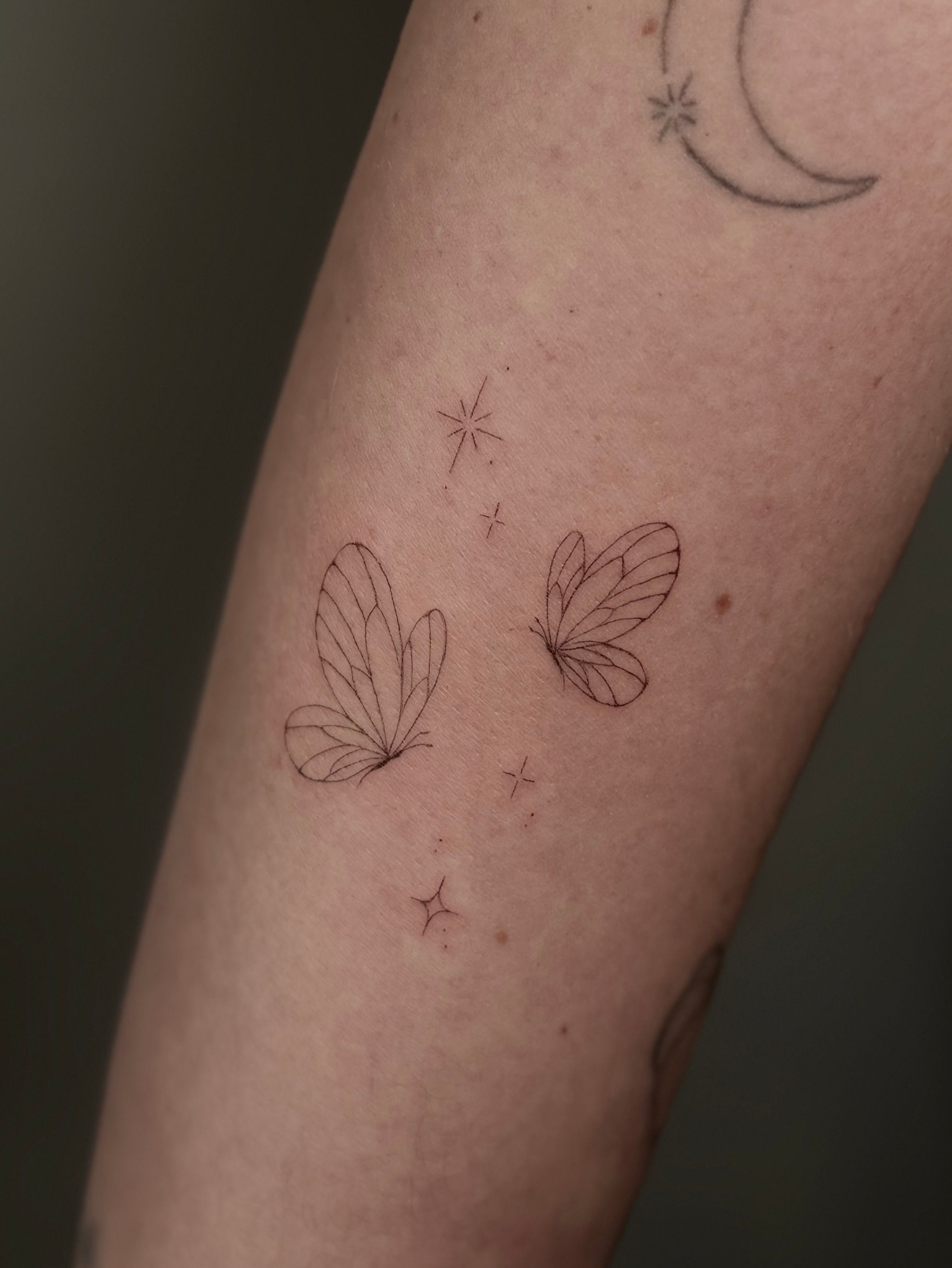 Schmetterlinge mit Sternen im Fineline Style auf Unterarm von Room 23 tattoo & art in Lübeck