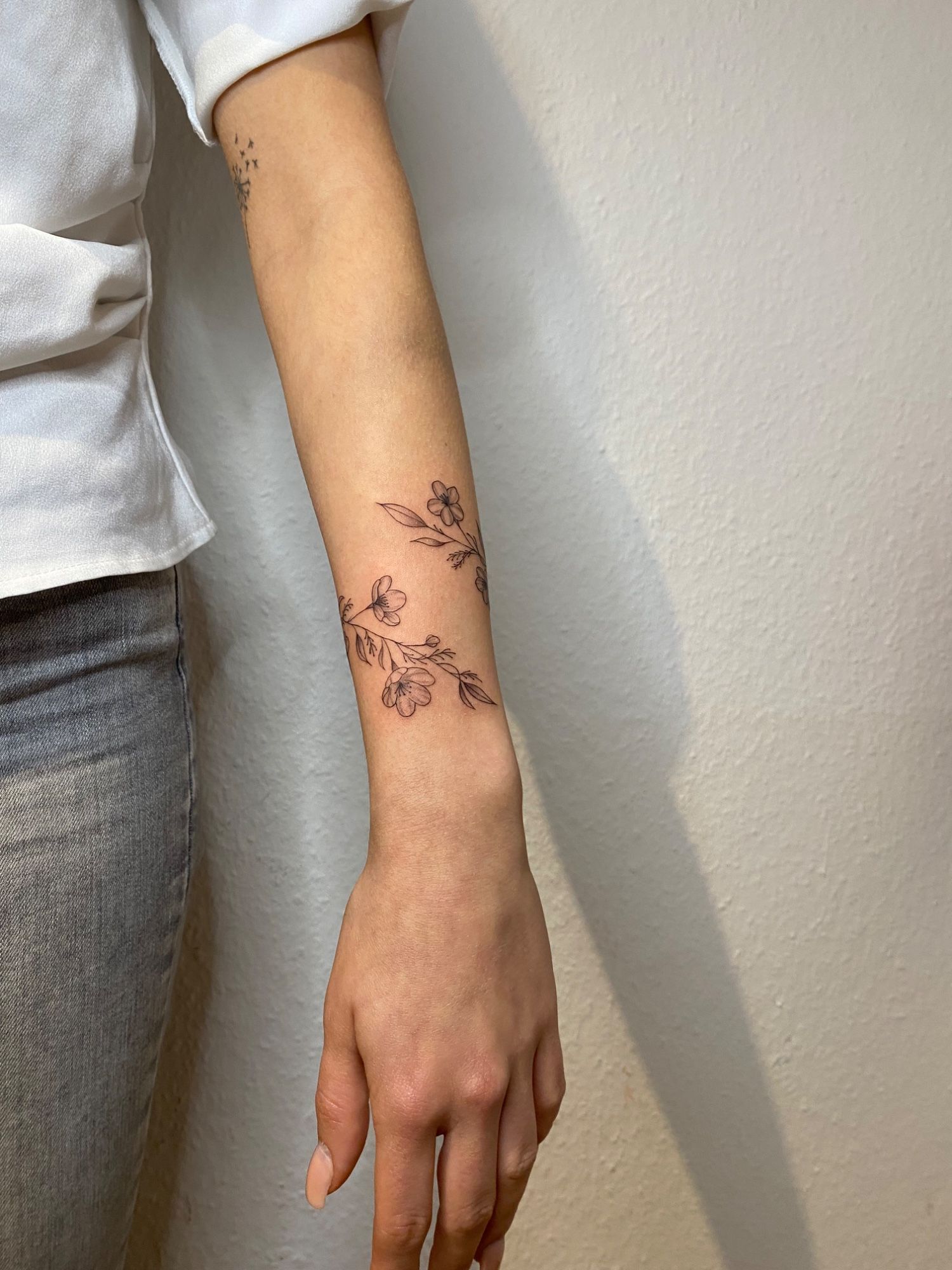 Floral Bracelet im Fineline Style auf Unterarm von Sadmeply Tattoo in Hamburg
