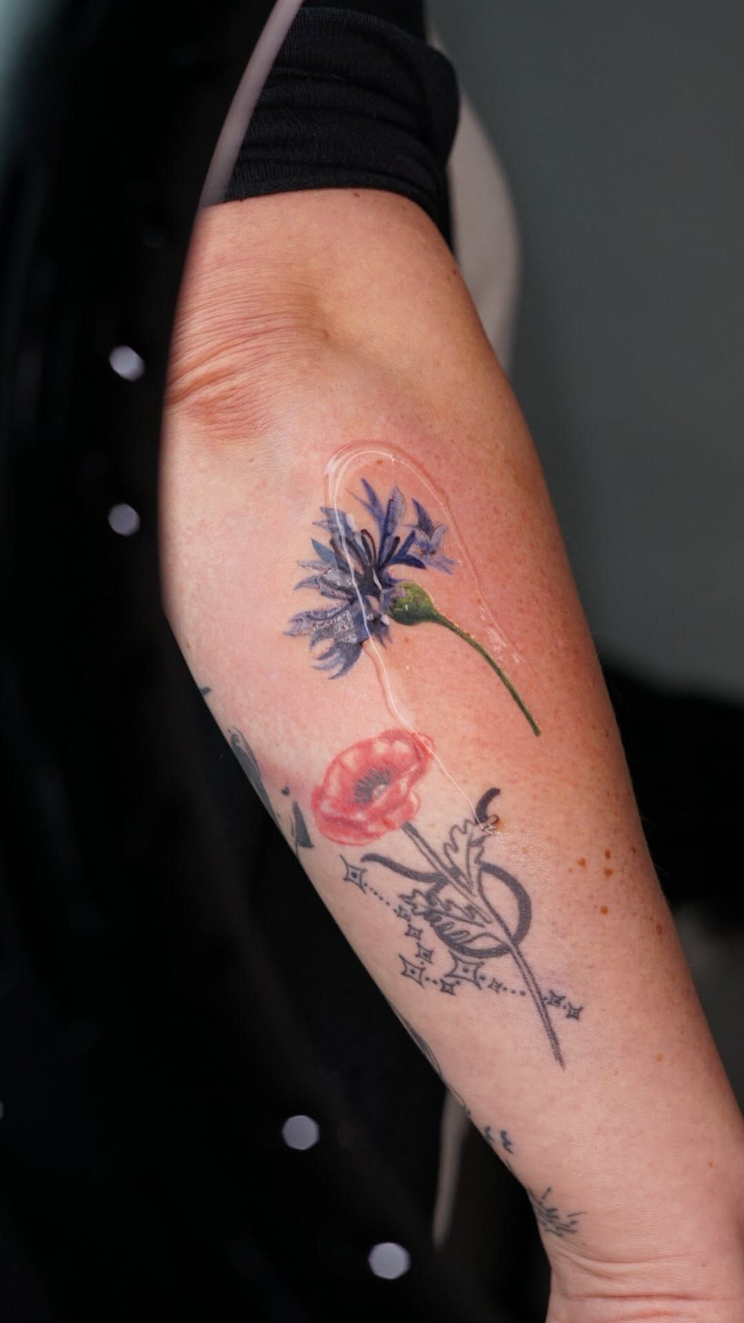 Blumen Illustrative Oberarm-Tattoo im Style auf Oberarm von kaleriiaa tattoo in Lübeck
