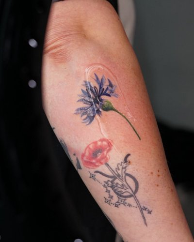 Blumen Illustrative Oberarm-Tattoo im Style auf Oberarm von kaleriiaa tattoo in Lübeck