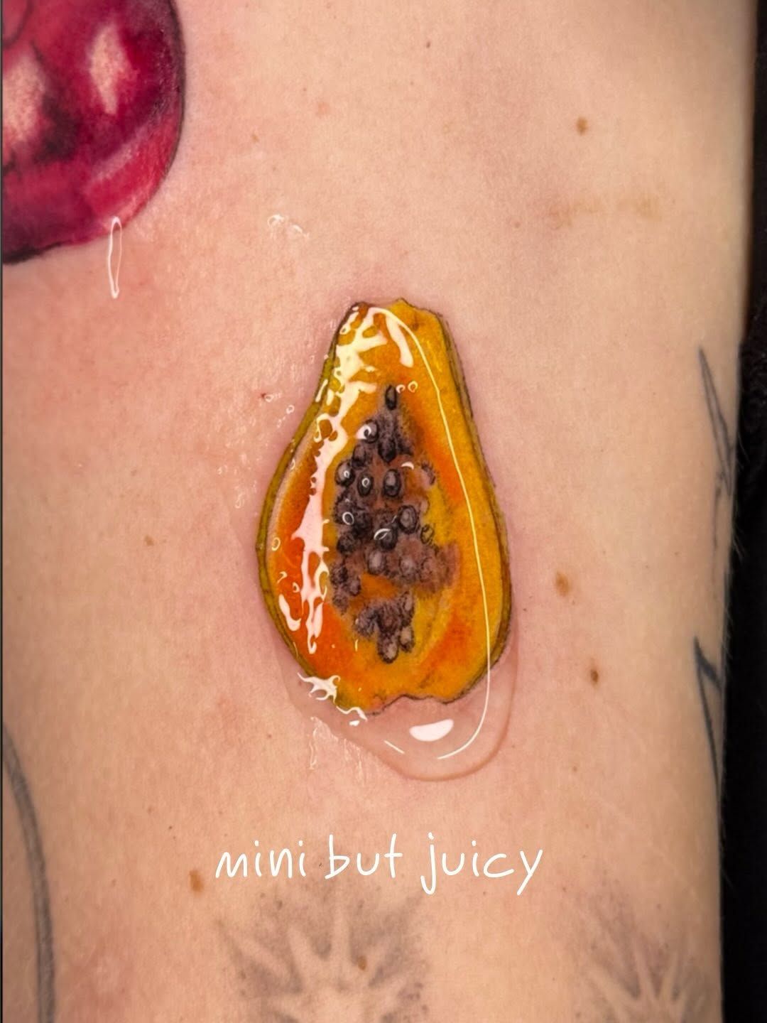 Papaya Realistische Oberarm-Tattoo im Realistic Style auf Oberarm von kaleriiaa tattoo in Lübeck
