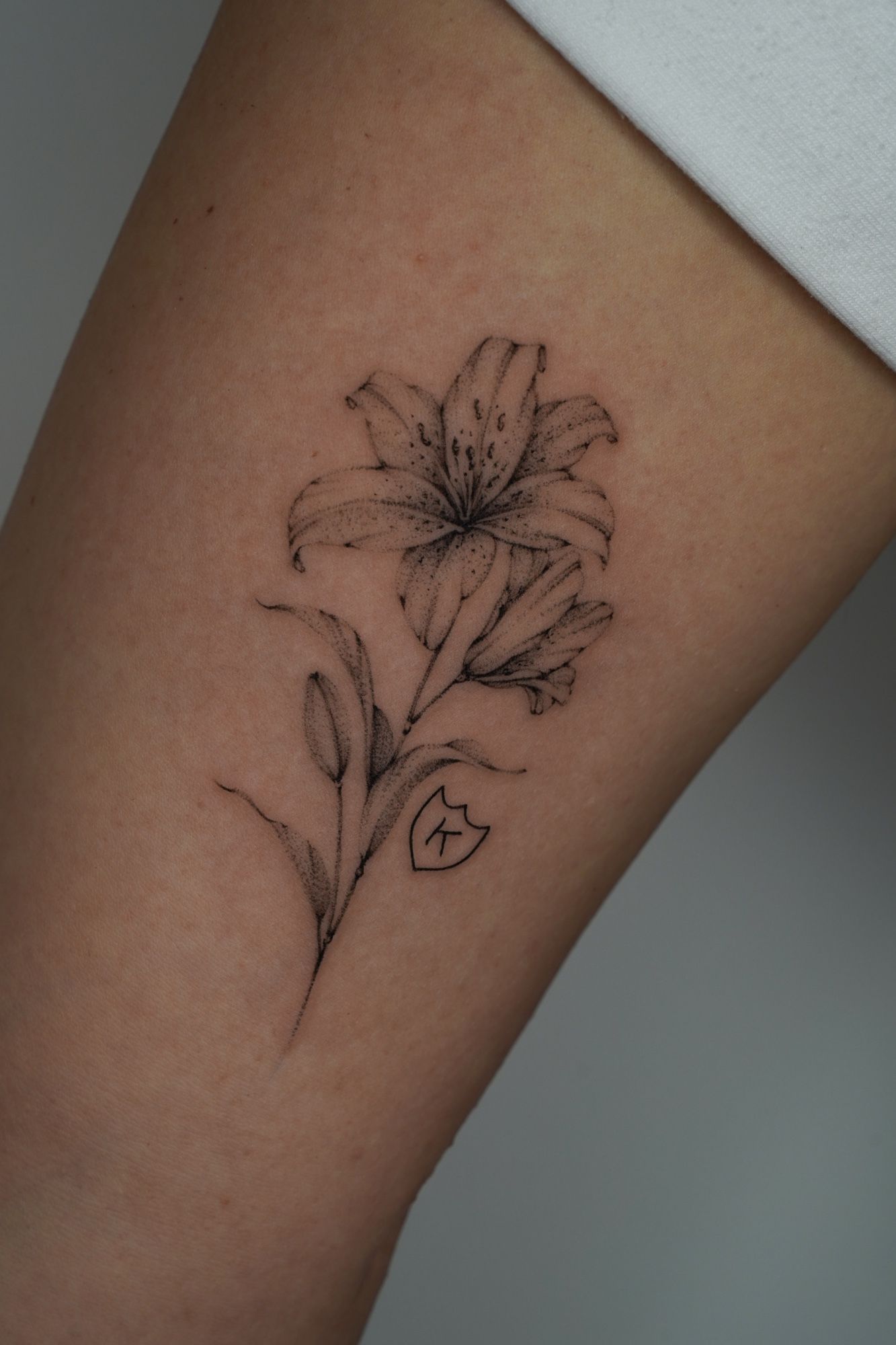 Lilie im Botanical, Floral Style auf Oberarm von Ziska Ink Tattoo Studio in 27339