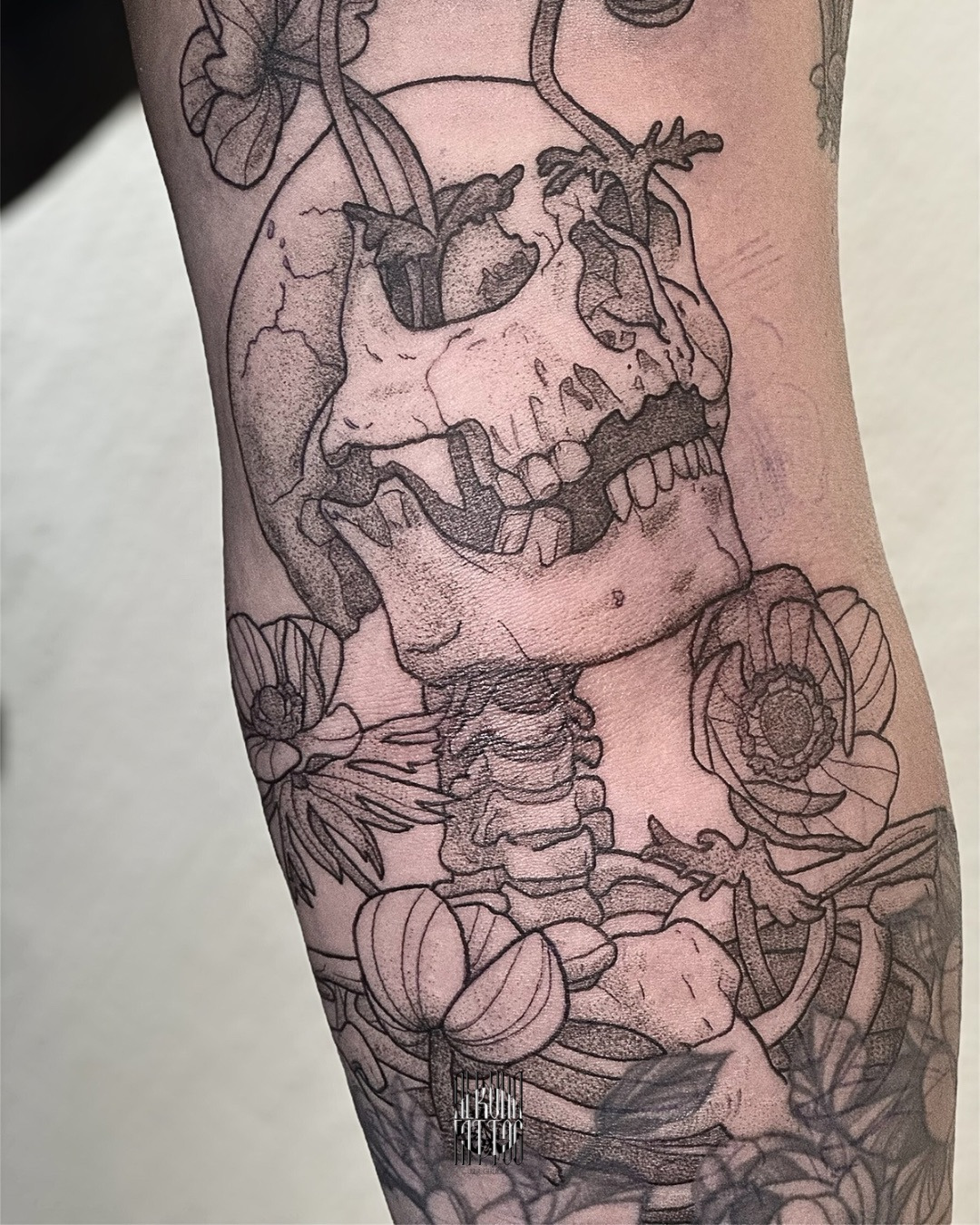Schädel mit Anemonen - erweitertes Wannado im Black & Gray Style auf Oberarm von Alruna Tattoo in Leipzig