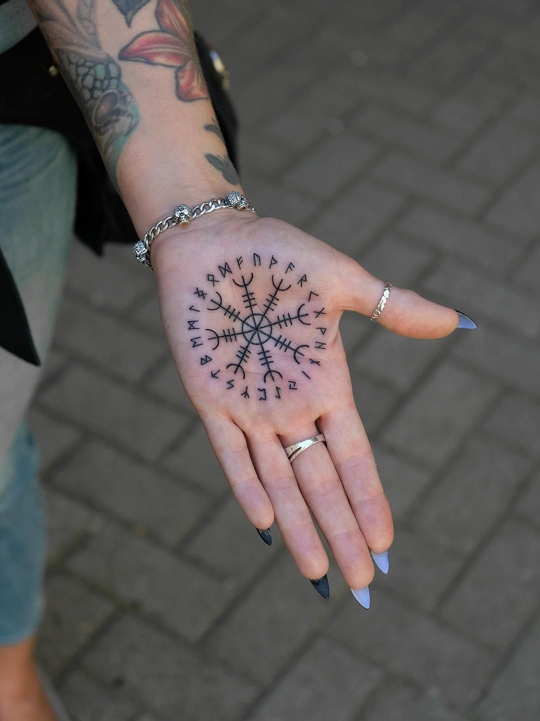 Runenkreis Blackwork Hand-Tattoo im Style auf Hand von Ink Doctor Tattoo in Hamburg