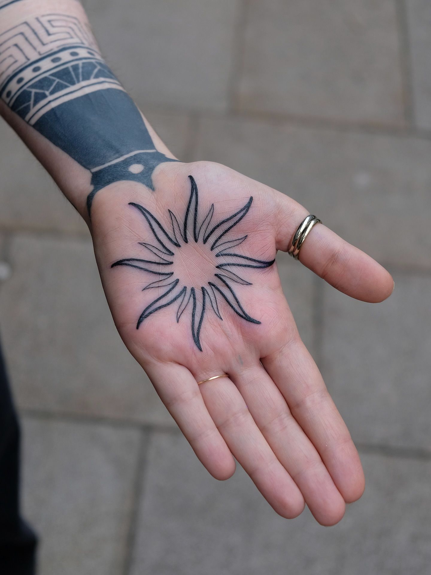 Sonne Blackwork Hand-Tattoo im Style auf Unterarm von Ink Doctor Tattoo in Hamburg