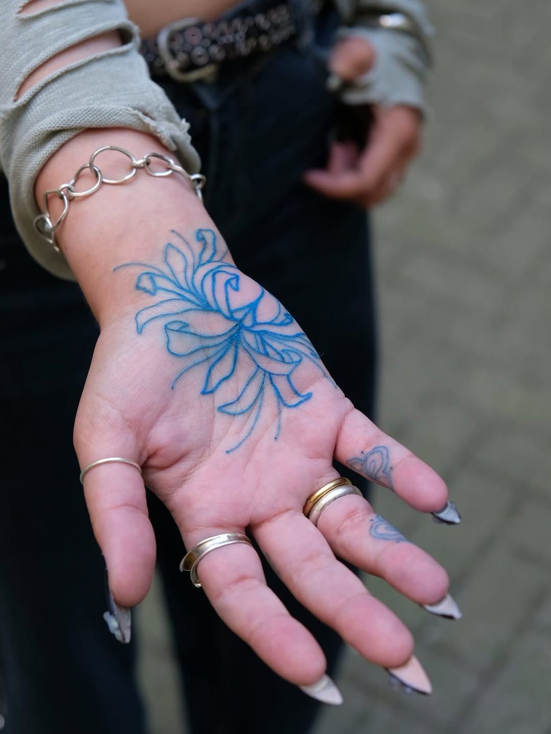 Blume Line Work Hand-Tattoo im Style auf Hand von Ink Doctor Tattoo in Hamburg