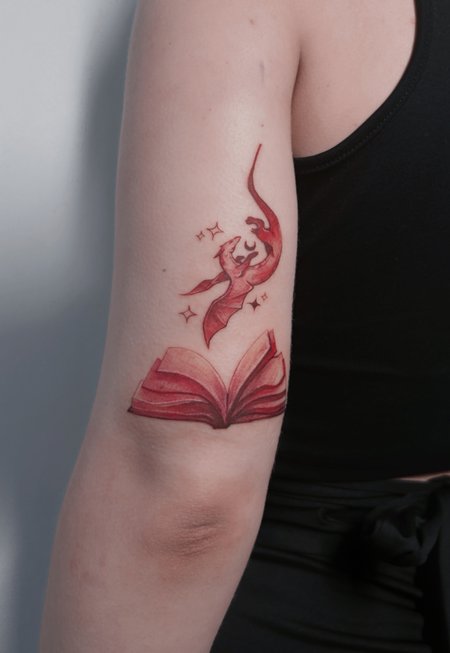 Dragon and book in Illustrative style on Upper Arm by Atelier tat Leipzig