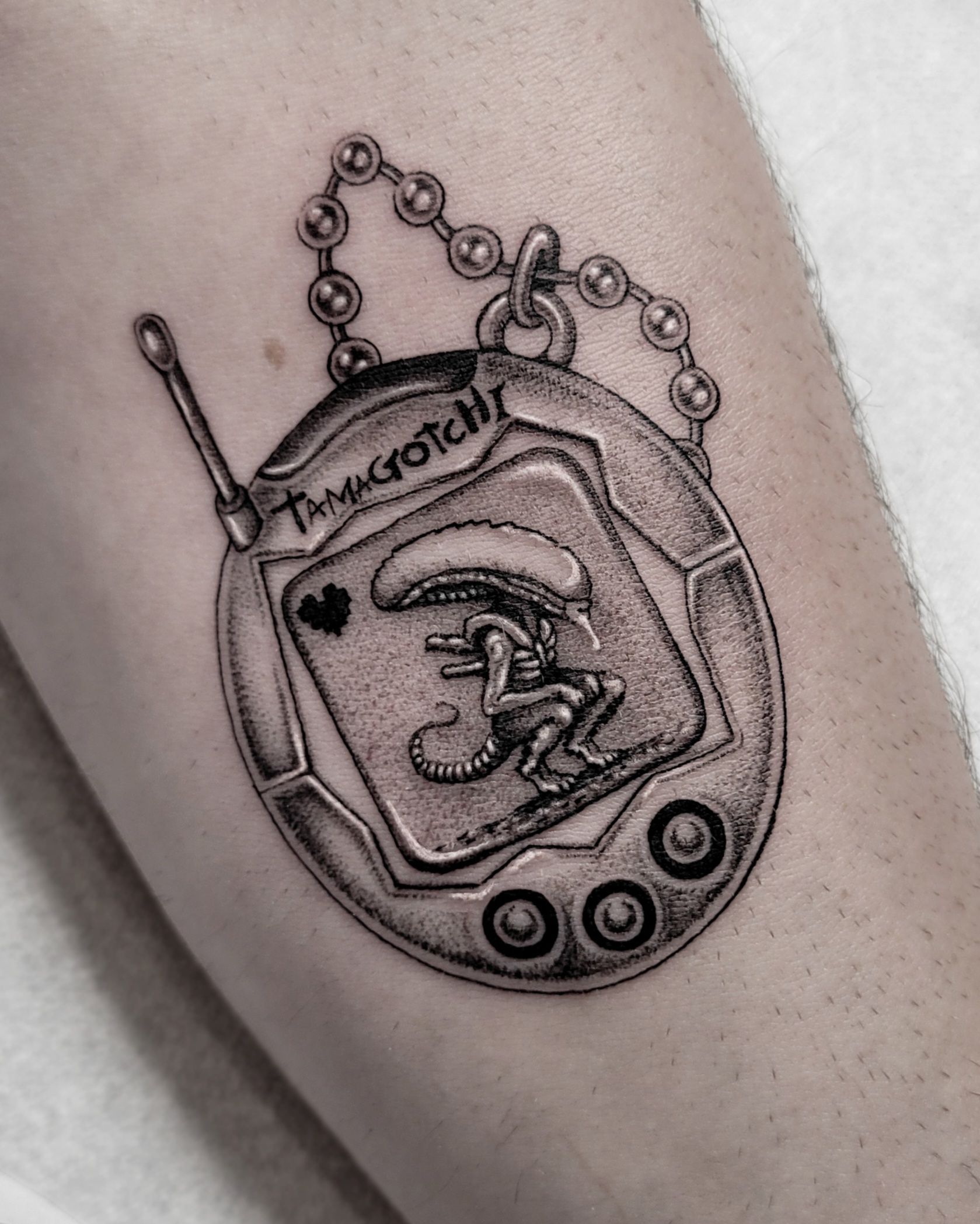 Alien Tamagotchi im Fineline Style auf Unterarm von Vivacervato in Leipzig