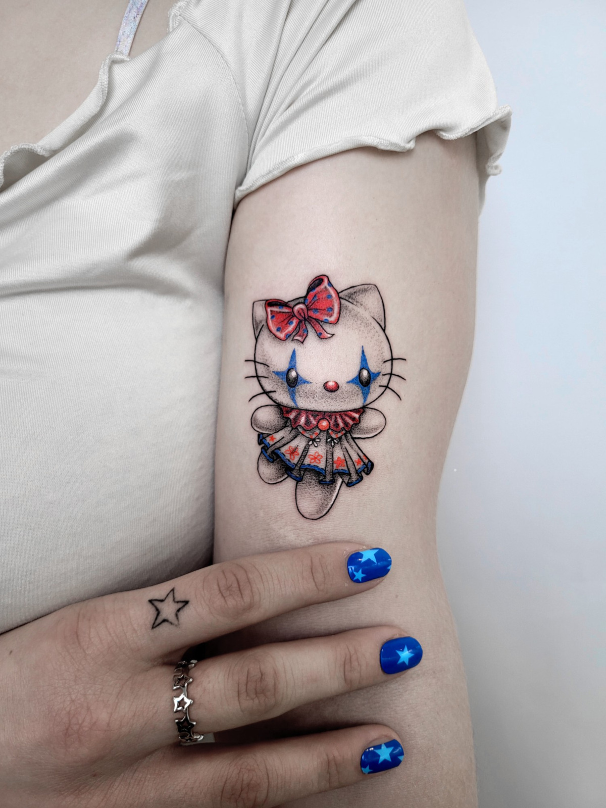Clowny Hello Kitty im Fineline Style auf Oberarm von Vivacervato in Leipzig