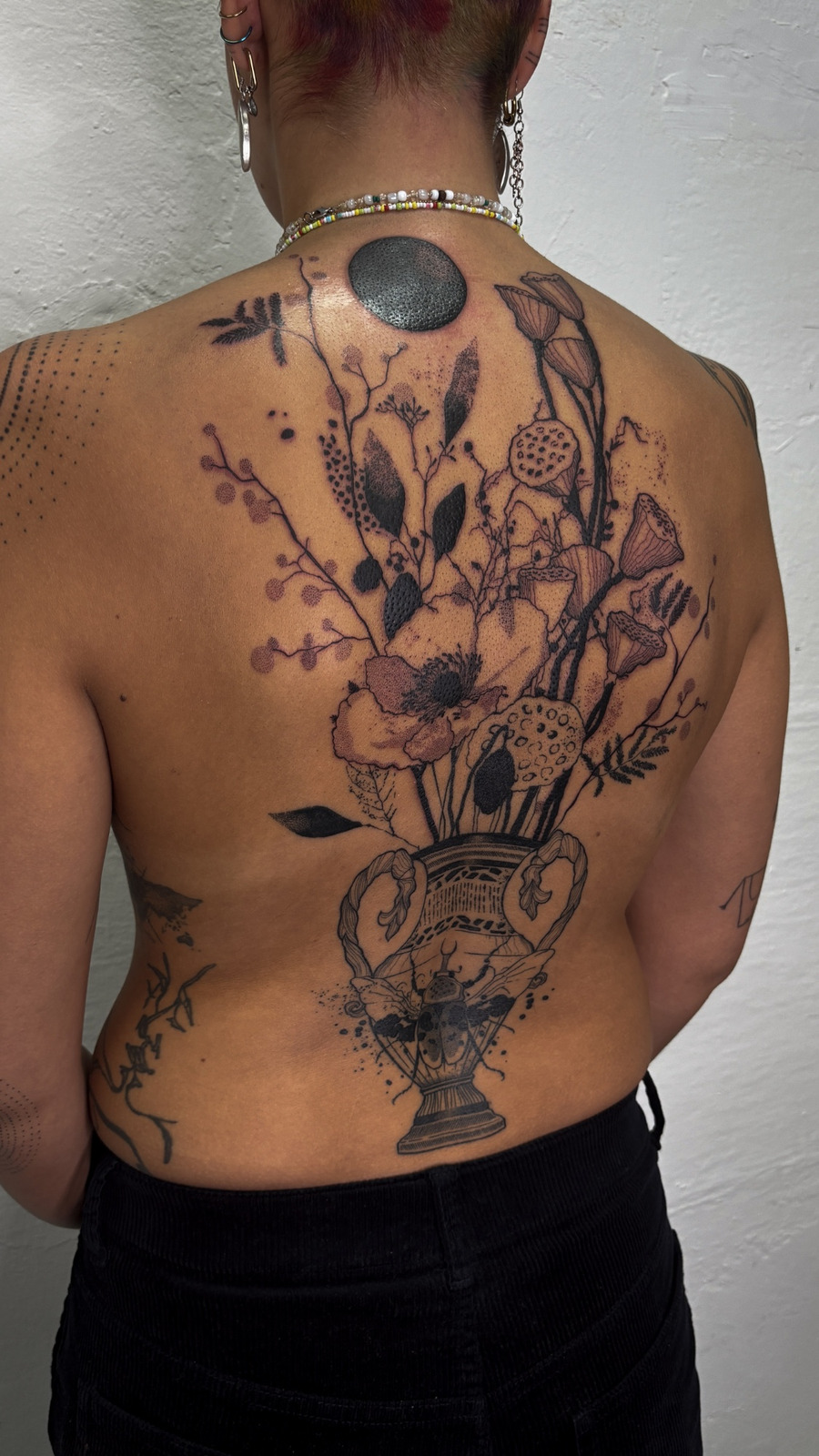 Vase mit Blumen Tattoo im Blackwork Style auf Rücken von Mörfi in 70372