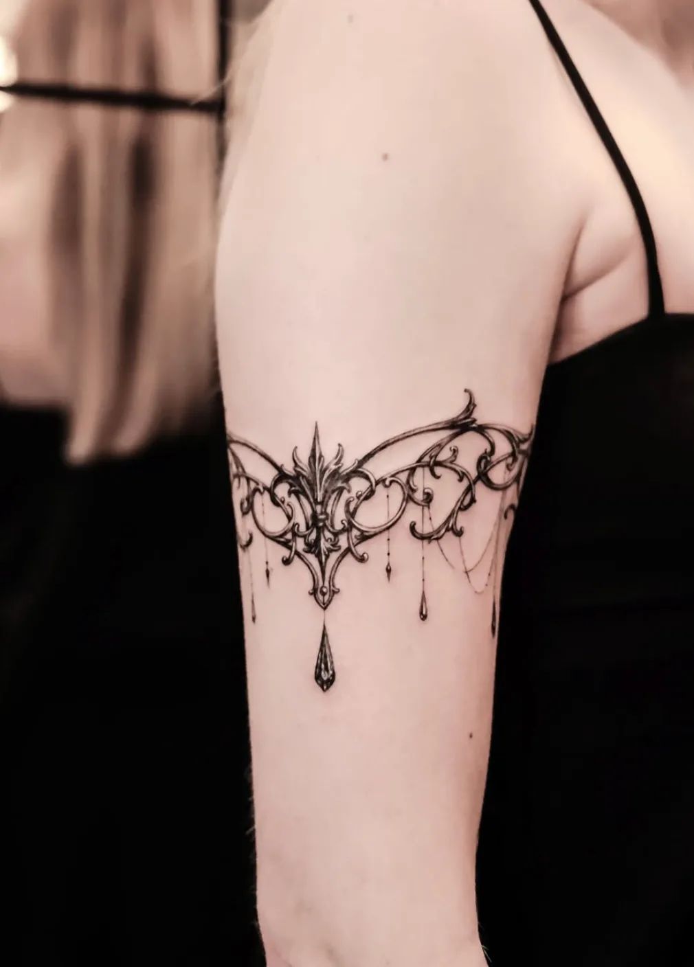Filigree bracelet tattoo in ornamental style on upper arm
