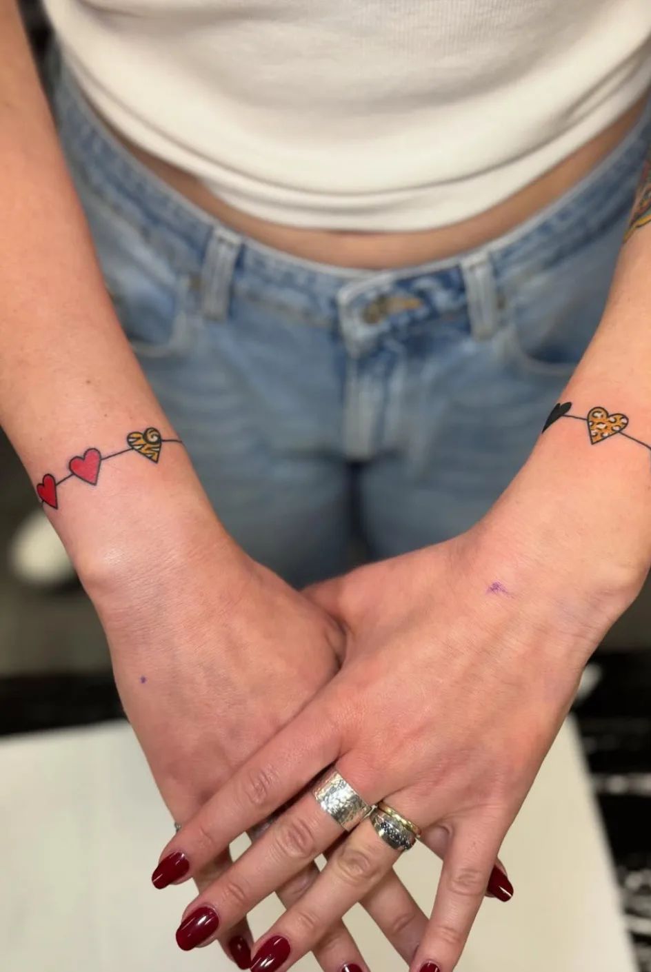 Armring tattoo with hearts and leopard print on wrist