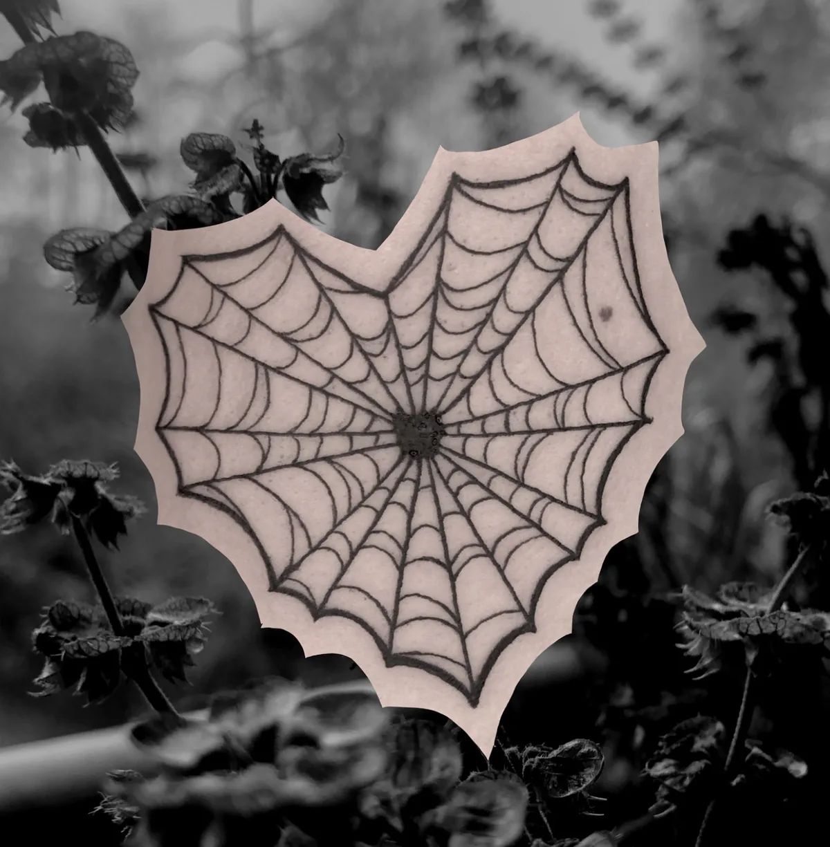 Heart spider web tattoo in fine line style