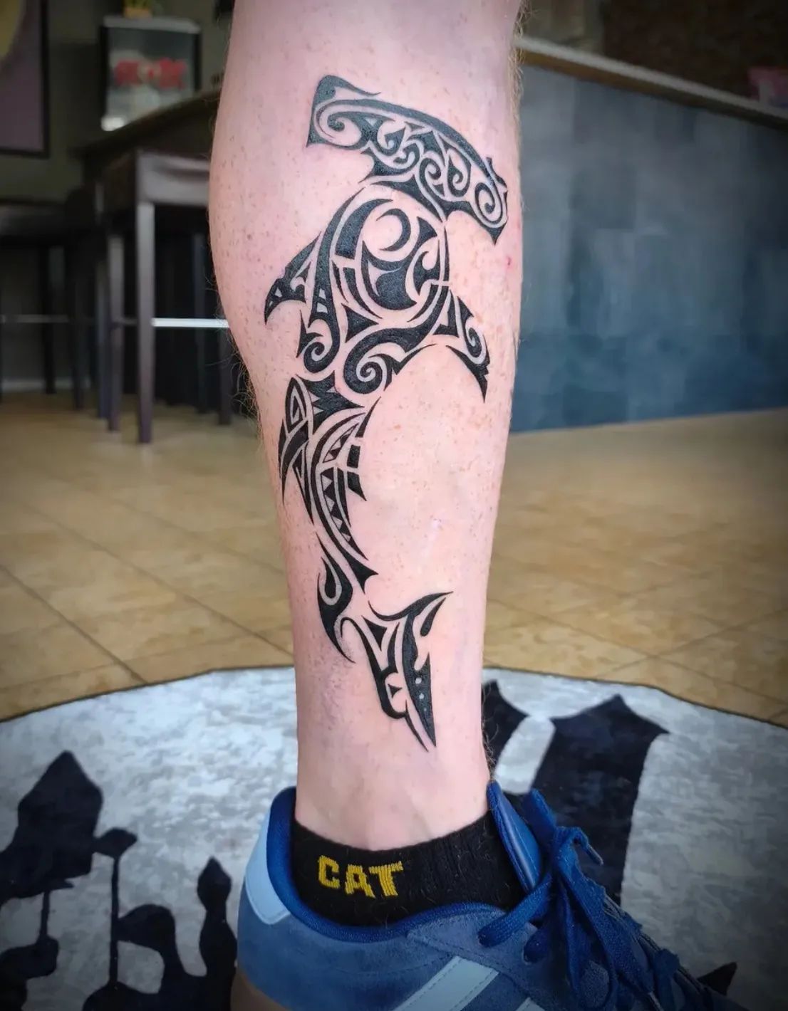 Maori hammerhead shark tattoo in tribal style on lower leg