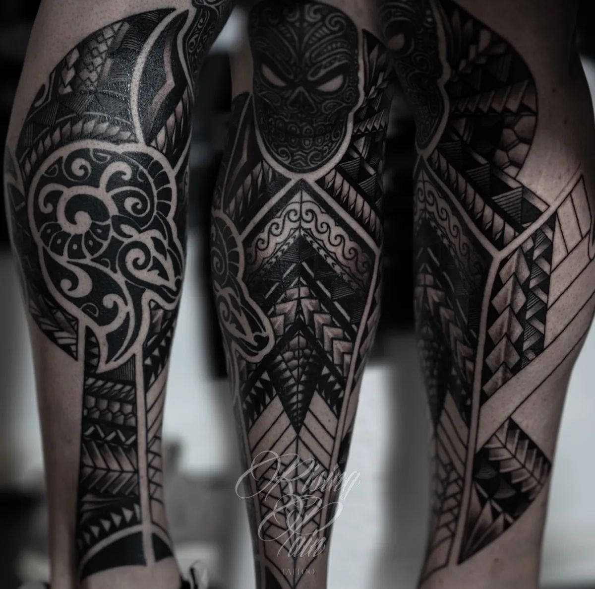 Maori tattoo with skull and geometric patterns on calves