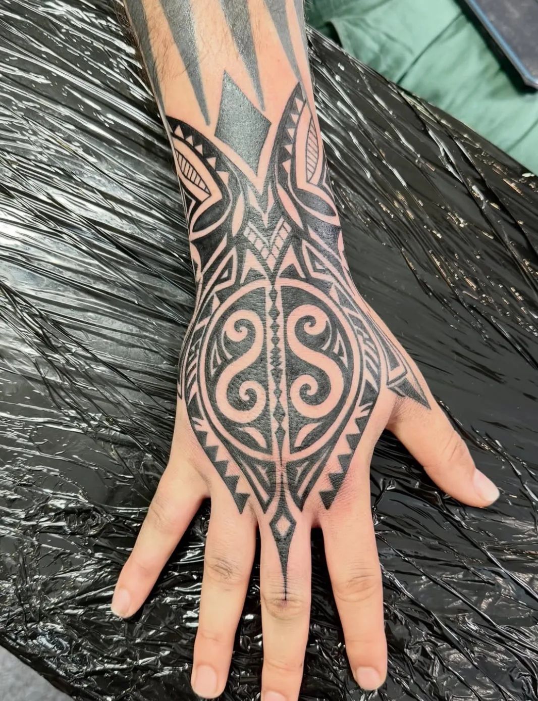 Maori tribal style tattoo on hand and forearm