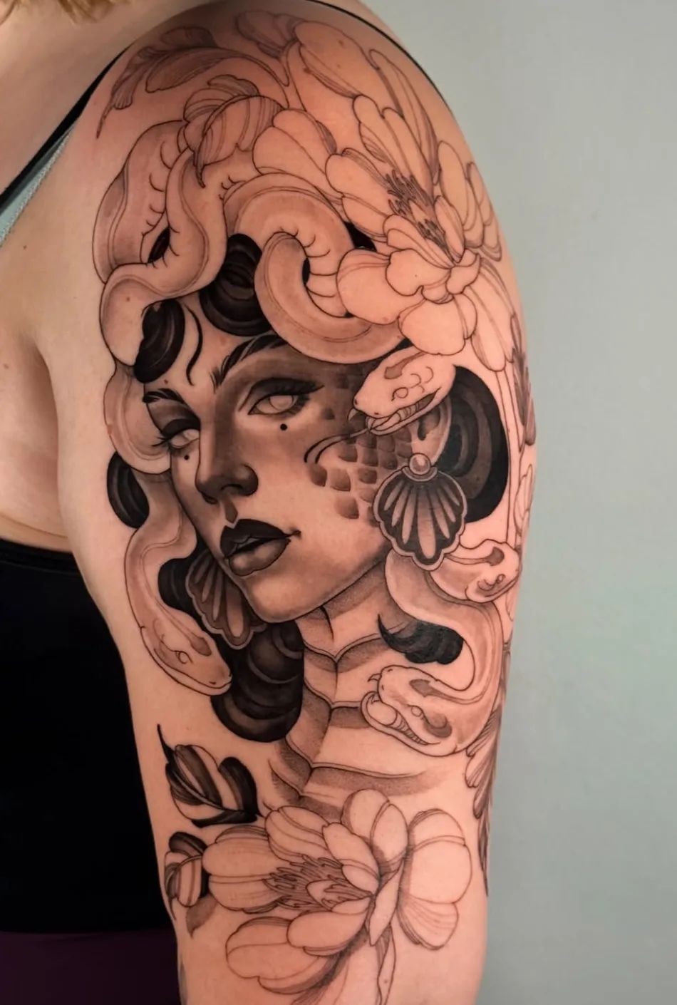 Medusa Tattoo im Neotraditional-Stil auf dem Oberarm mit Schlangen und Blumen
