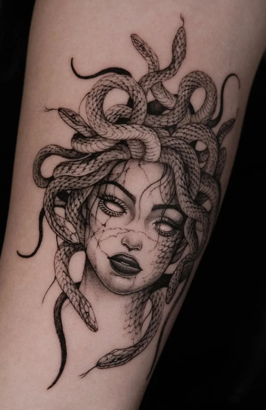 Realistisches Medusa Tattoo im Fineline-Stil mit Schlangenhaaren und Rissen im Gesicht