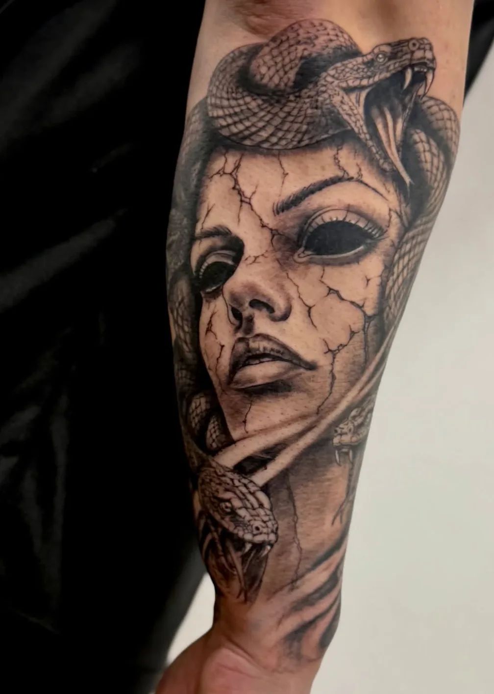Realistisches Medusa Tattoo mit Schlangen und rissiger Haut am Unterarm