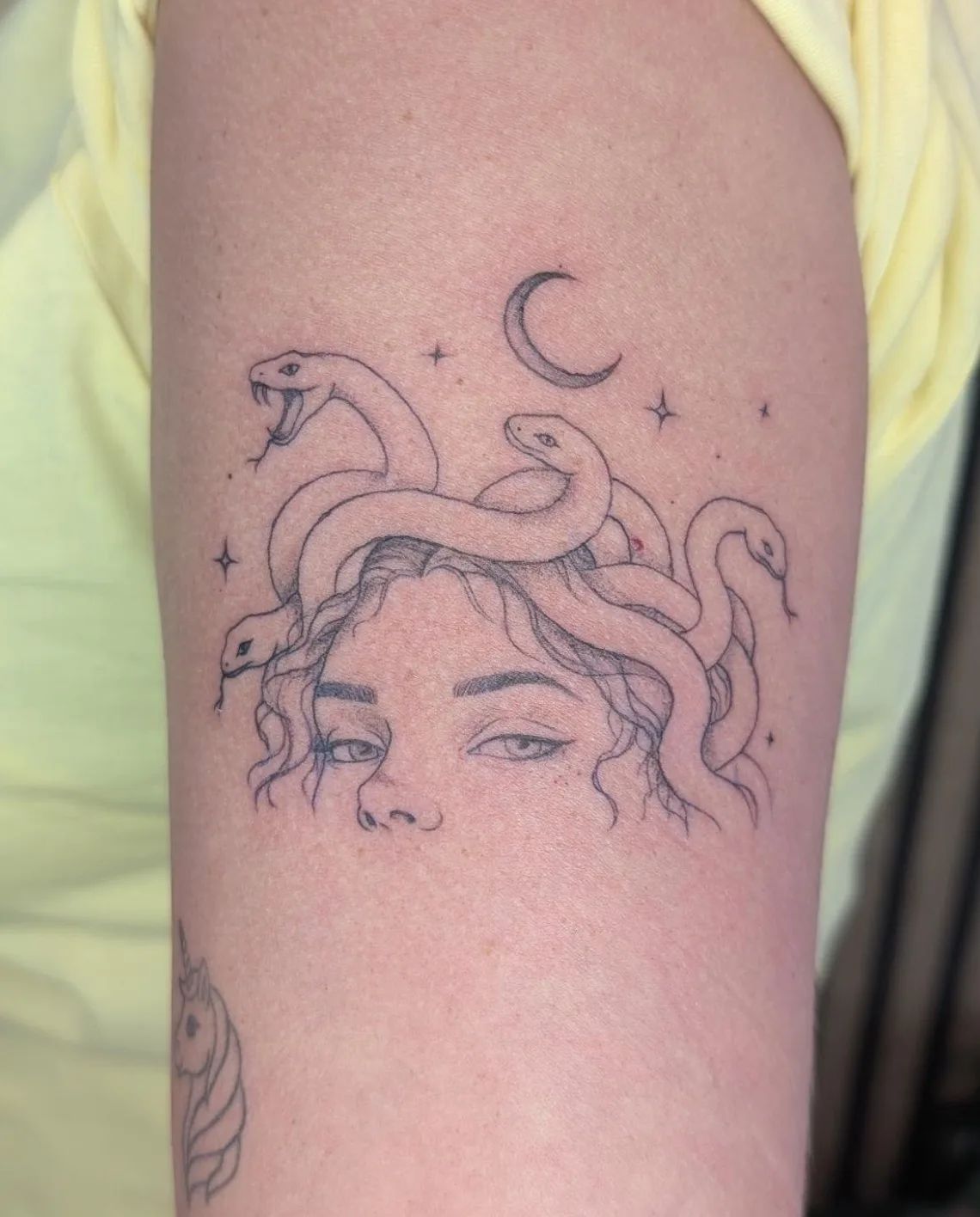 Medusa Tattoo Fineline am Oberarm mit Mondsichel und Sternen