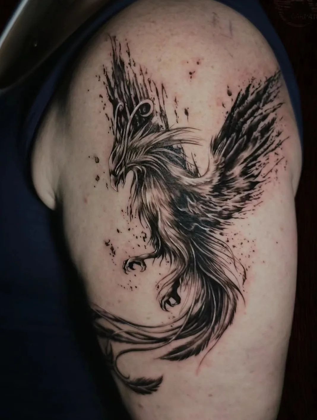 Trash Polka phoenix tattoo on upper arm