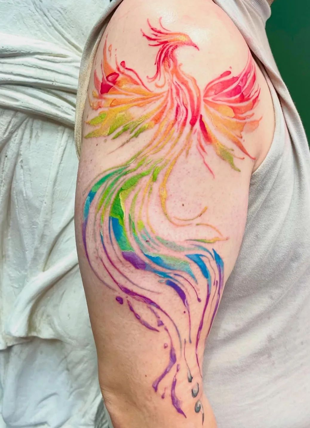 Watercolor phoenix tattoo on upper arm