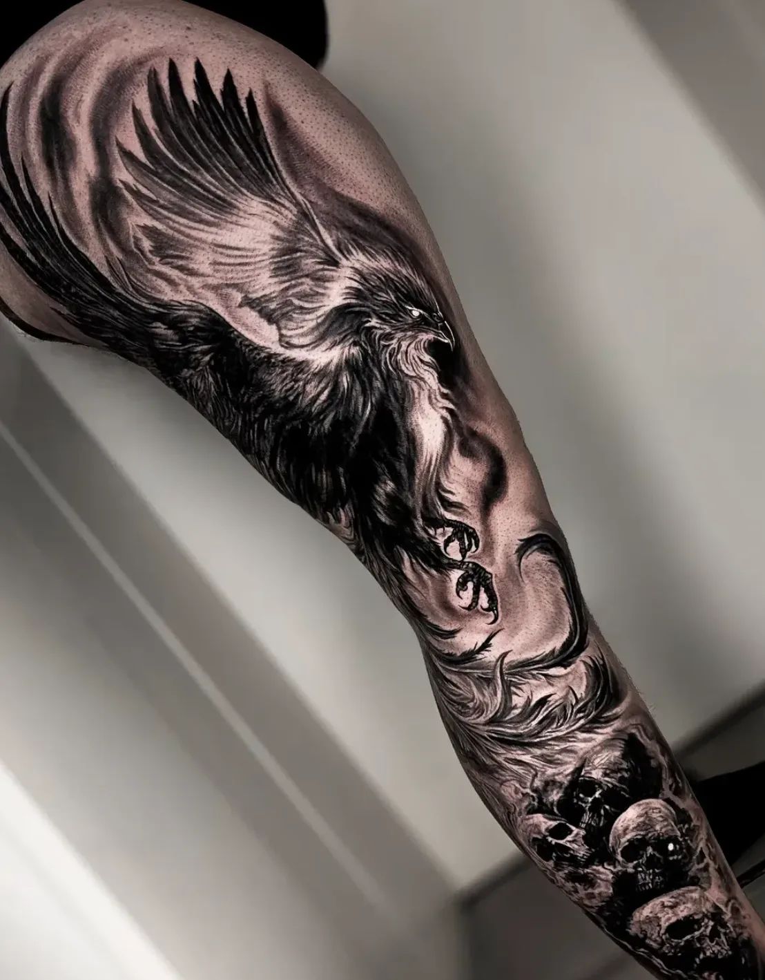 Realistic phoenix tattoo with skulls on leg